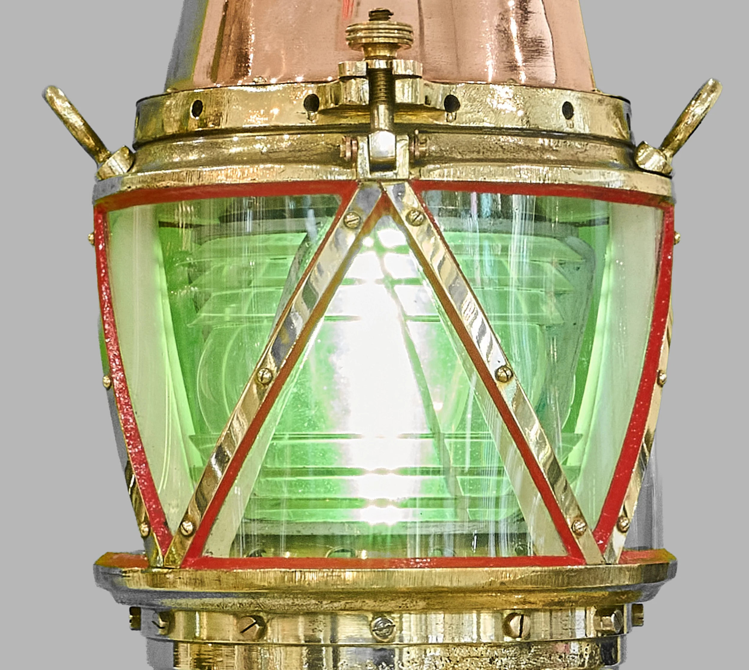 Stepped Fresnel optic glowing within green harbor beacon lantern and brass guards — Daniels Antiques