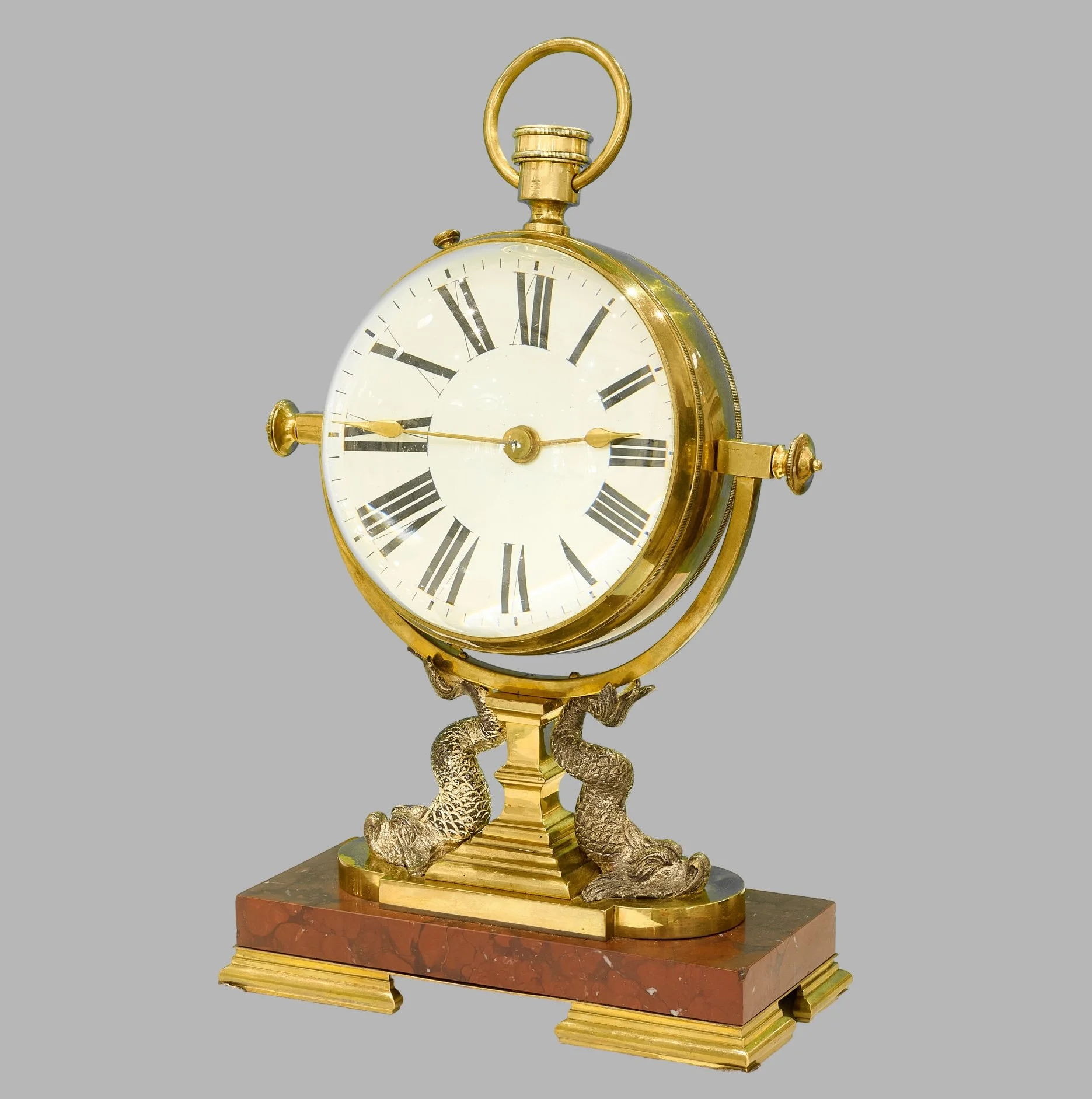 Three-quarter view of ball clock on rouge marble and dolphin base — Daniels Antiques