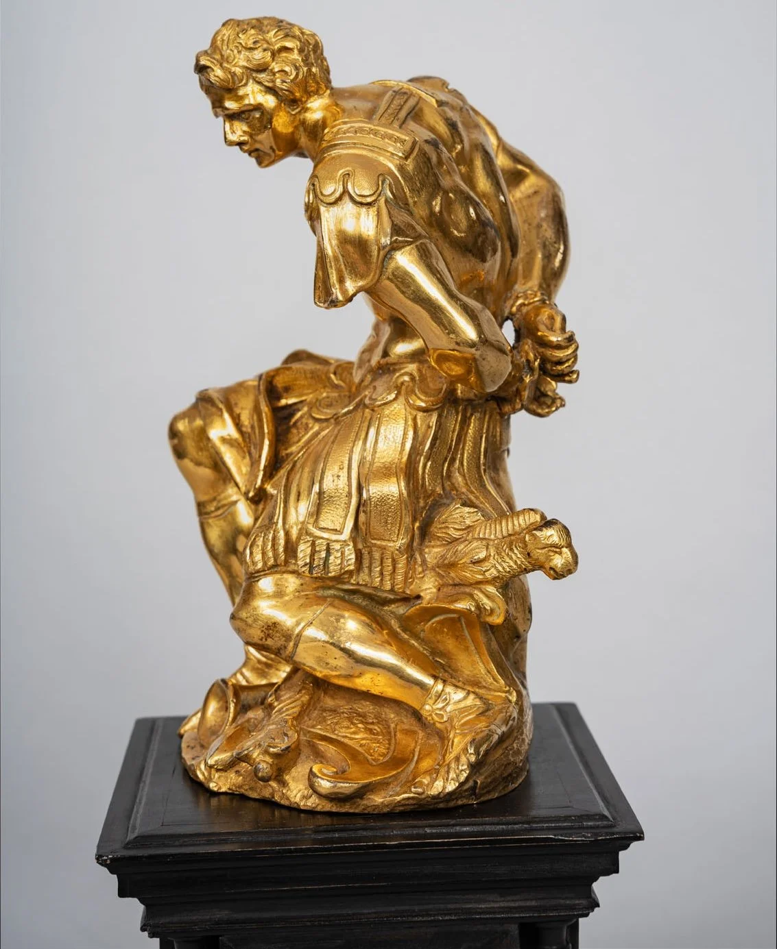 Gilt bronze Mars kneeling over the ram's-head sword, on ebonized socle — Daniels Antiques