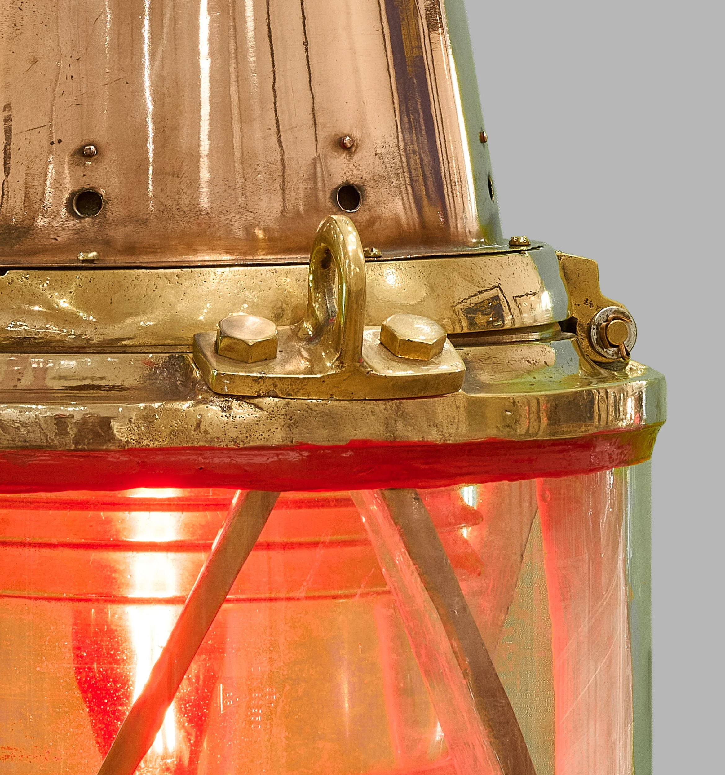 Red Fresnel lens, copper cowl and brass lifting lug of antique harbor beacon — Daniels Antiques