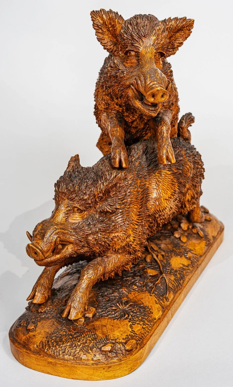 A Swiss Black Forest Carved Walnut Sculpture of Two Fleeing Boars, circa 1870.