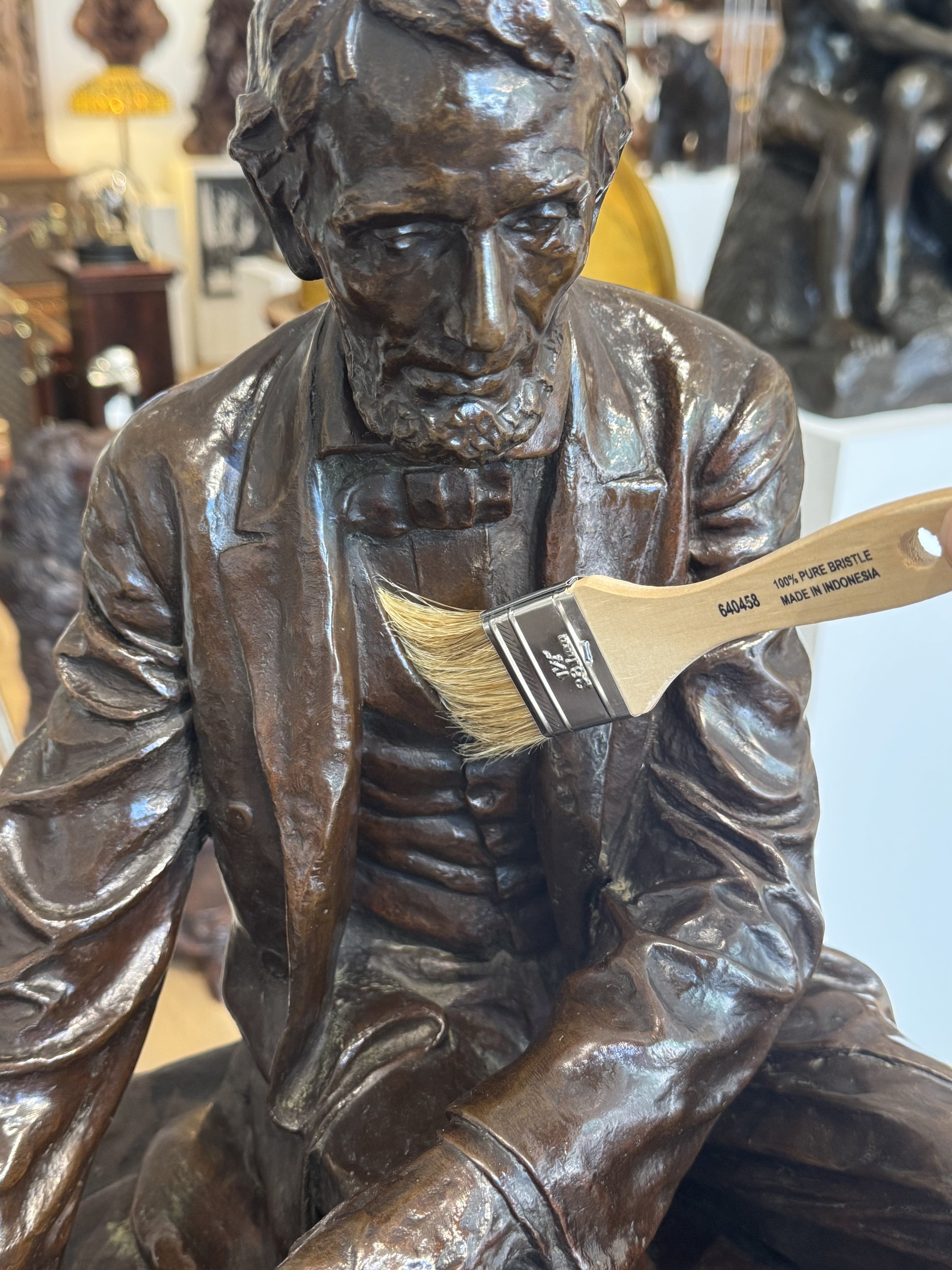 Dusting an antique bronze sculpture with a soft dry bristle brush — Daniels Antiques
