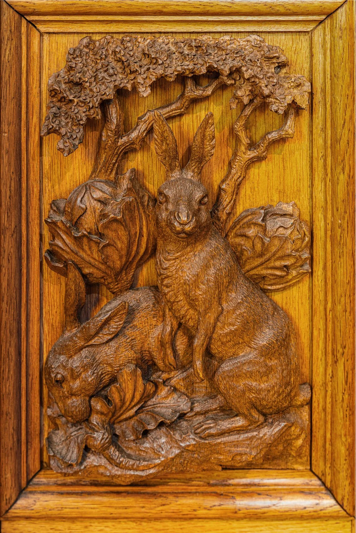Lower door panel carved in high relief with hares in woodland, Black Forest Jagdschrank, late 19th century