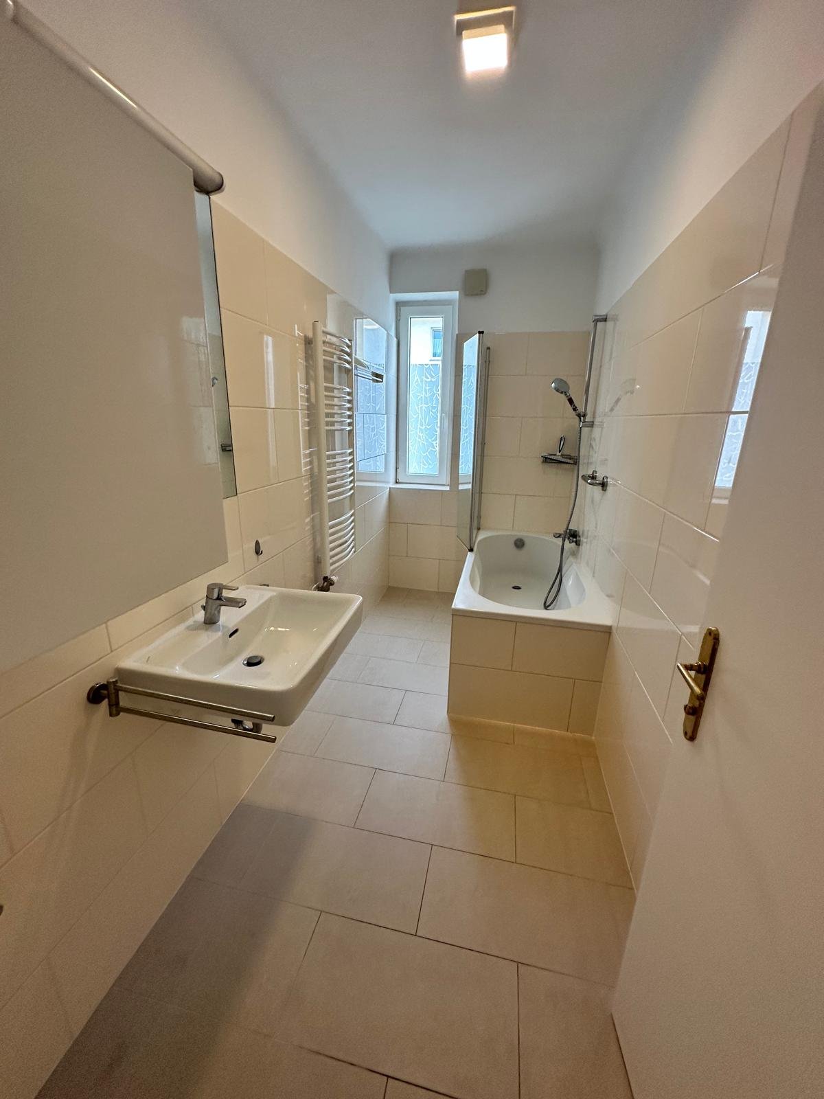 Badezimmer mit Badewanne, Dusche und Waschmaschinenanschluss