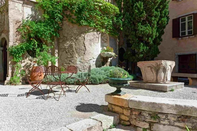 Courtyard With Gravel Floor A Set Of Outdoor Seating And A Water Fountain