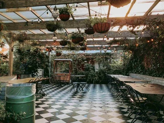 Black And White Floor In Courtyard With Tables And Chairs, Plants And Fairy Lights