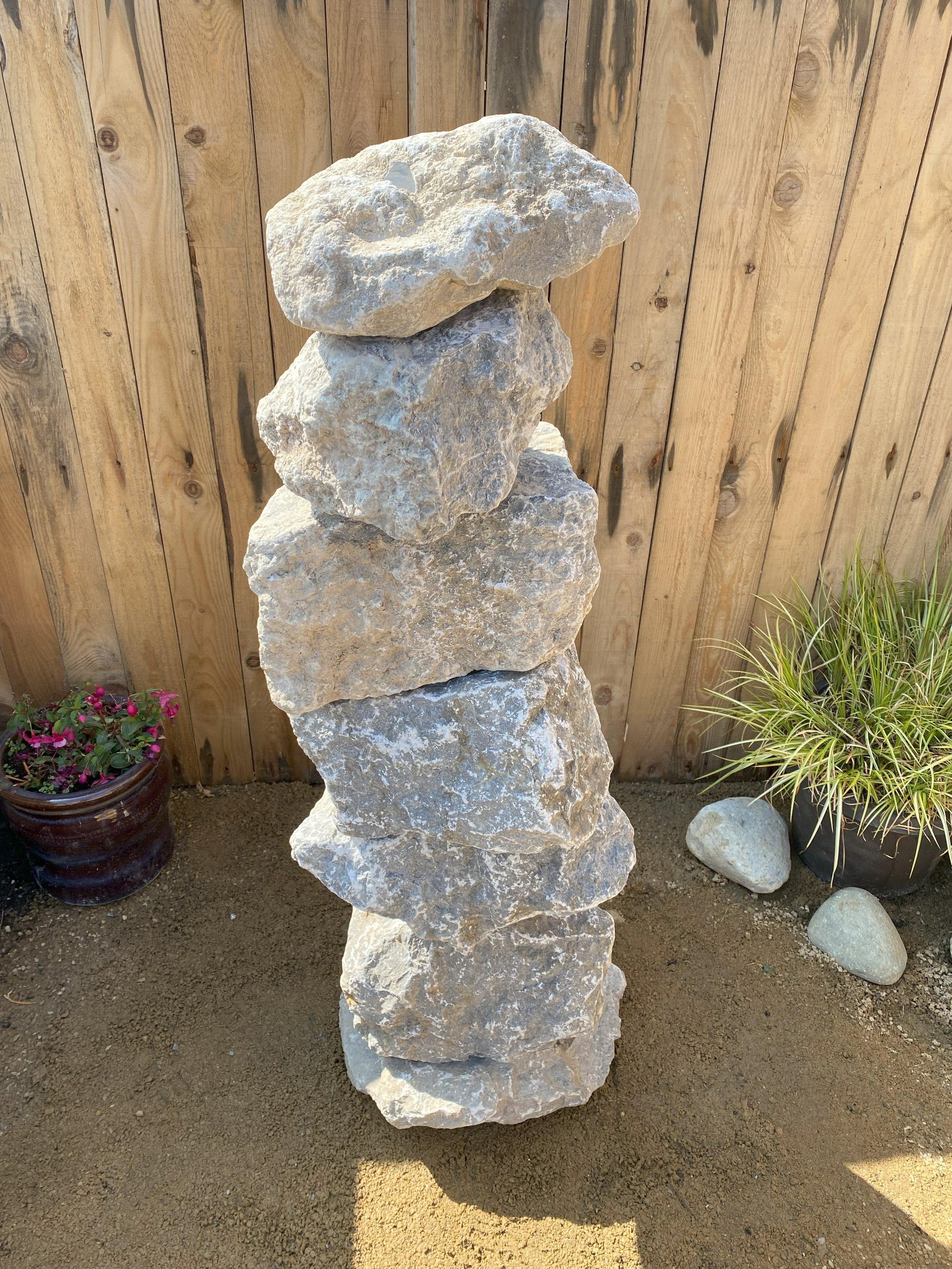 large drilled highland grey limestone stack in front of fence panelling