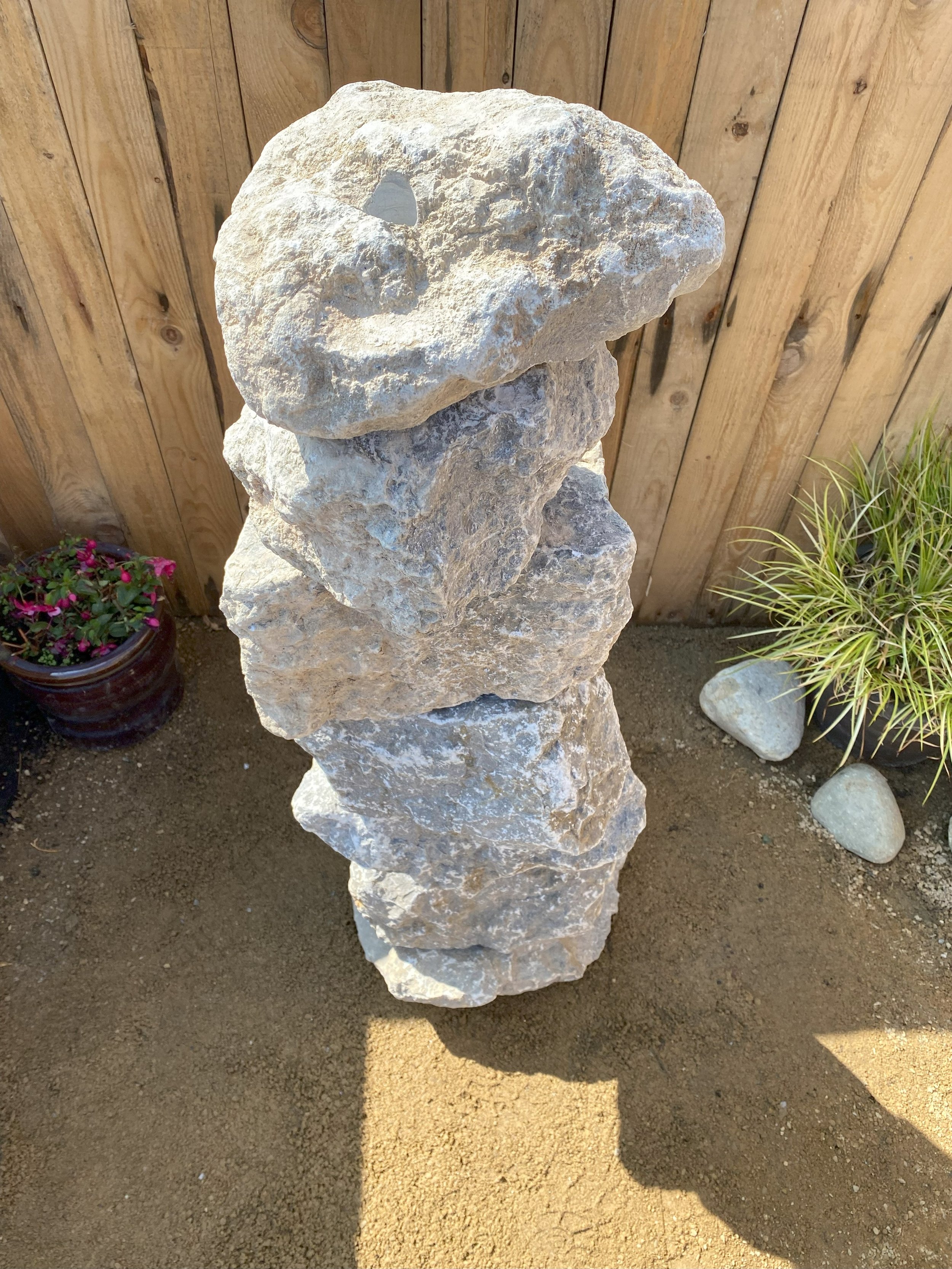 large drilled highland grey limestone stack in front of fence panelling