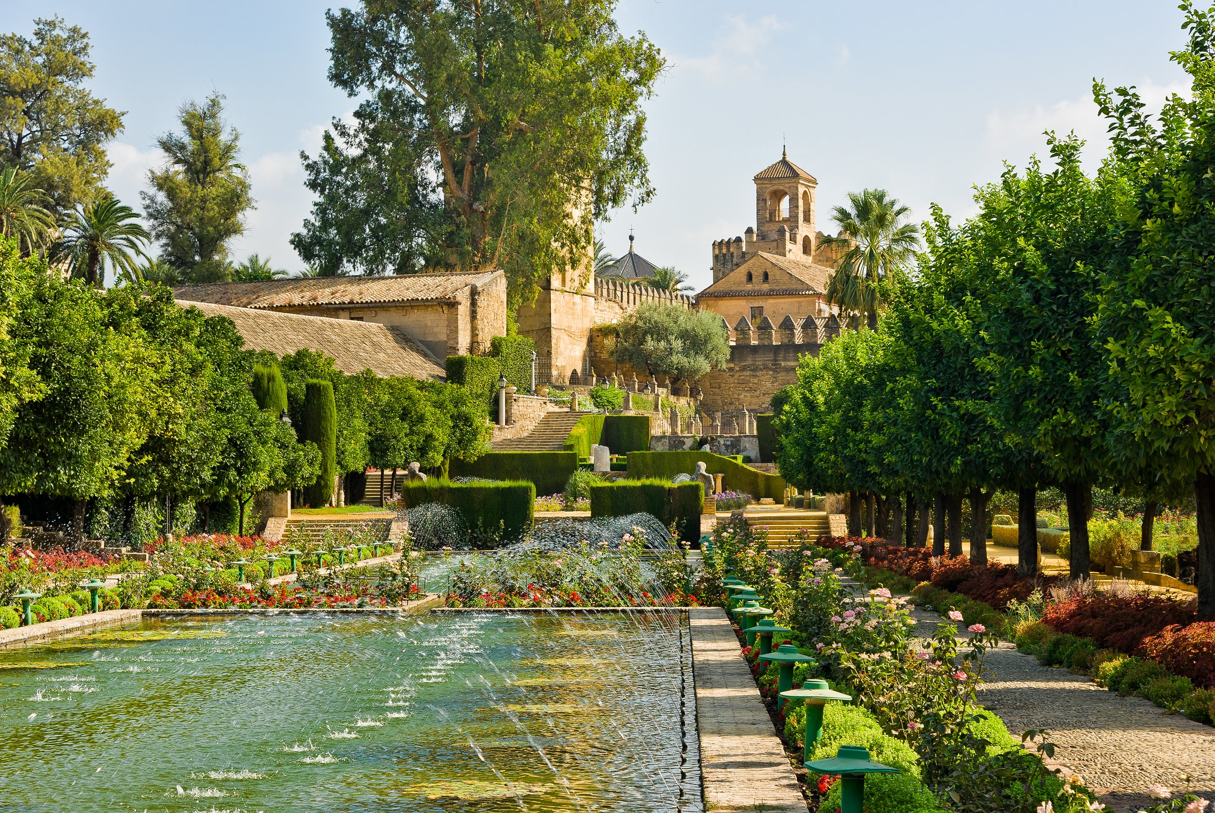 Mediterranean Garden With A Self Bind Alongside A Pond Sounded By Flowers And Trees