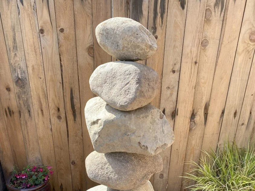 Pebble Water Feature In A Garden Setting Next To Plants