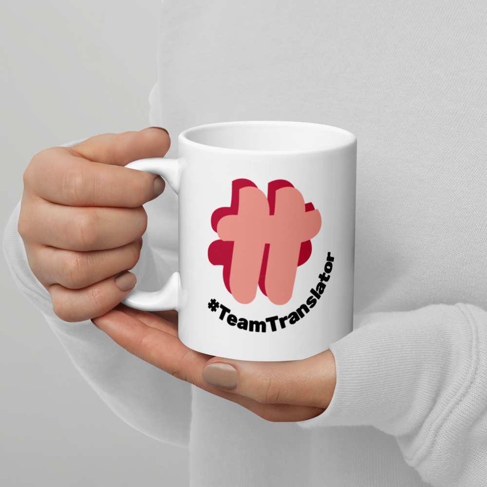 Person holding the mug in their hand, showing the logo side.