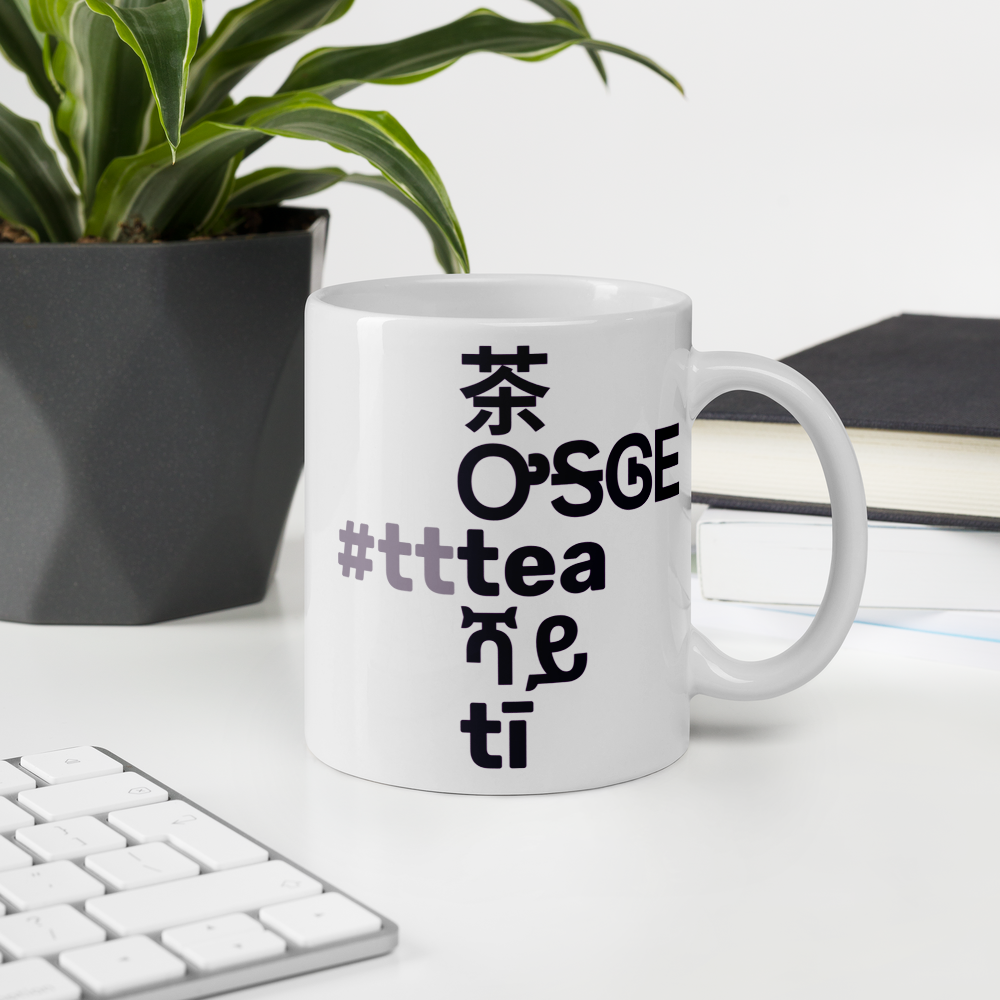 The mug on a desk, showing the "tea" side.
