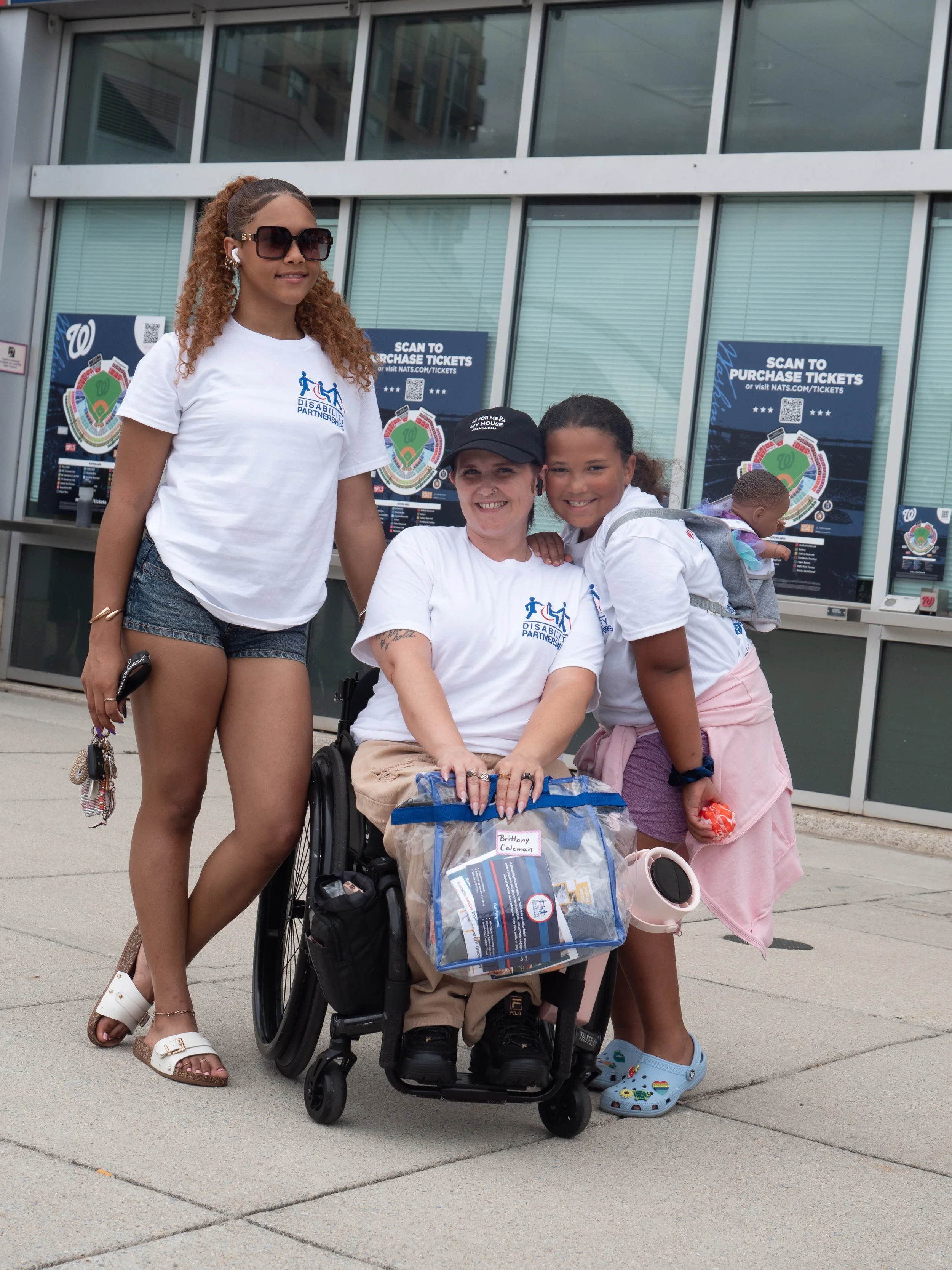Disability Partnerships attendee in a wheelchair poses with family members outside Nationals Park