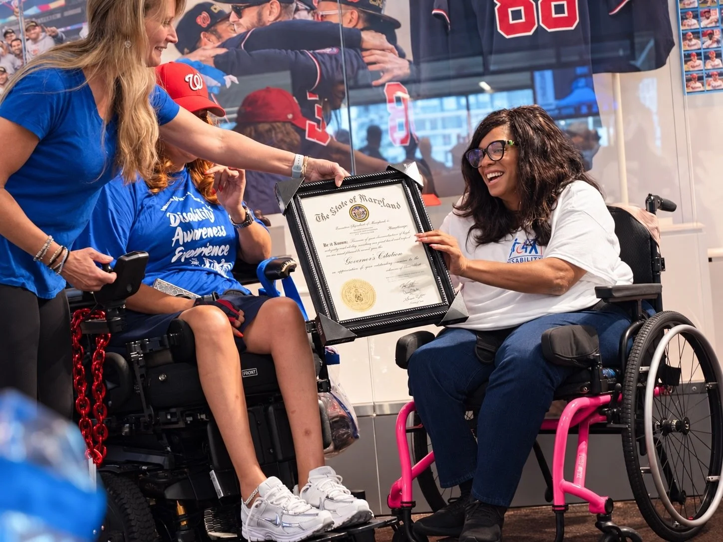 Disability Partnerships team members celebrate while presenting a Maryland Governor’s Citation