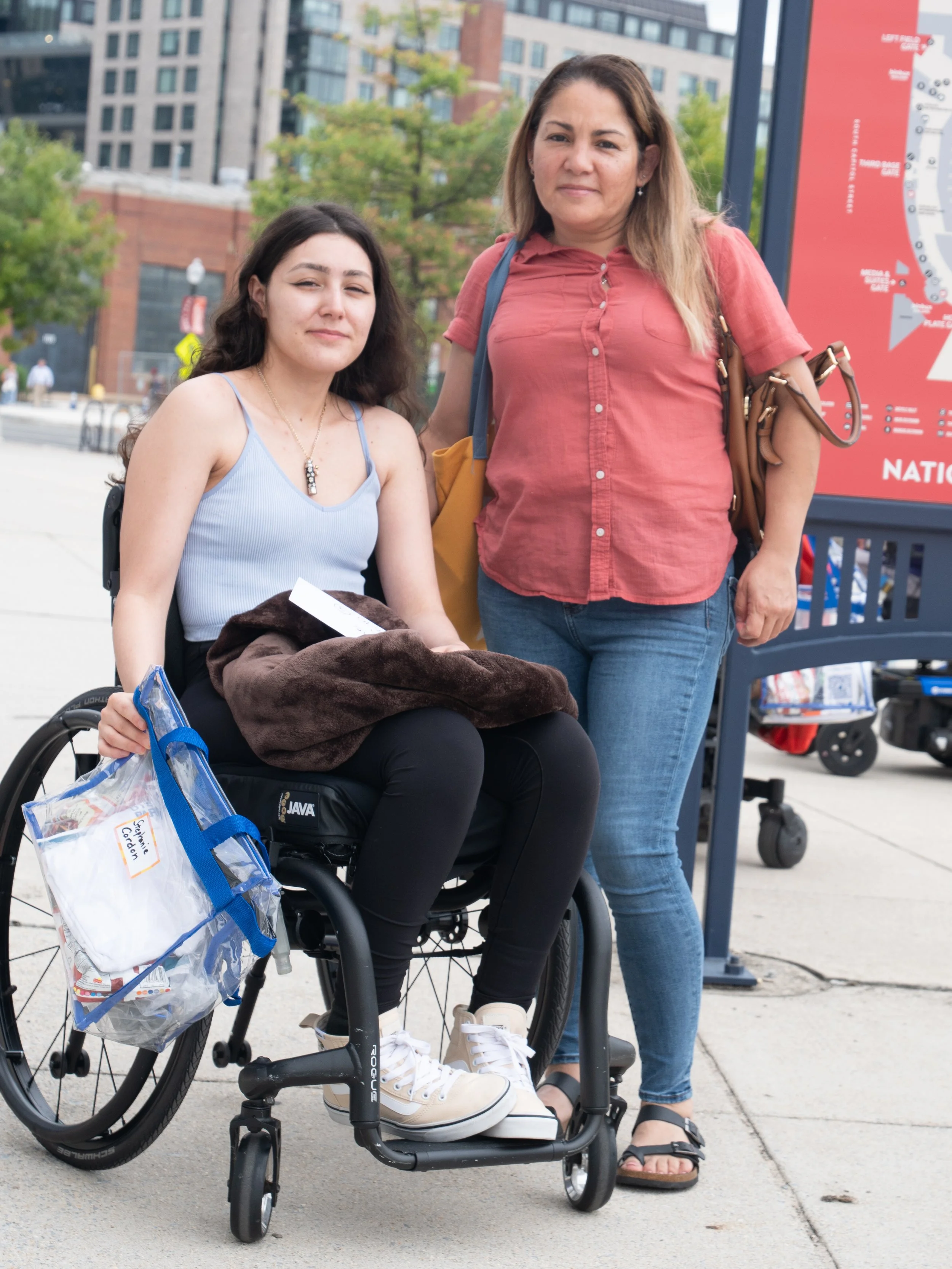 Wheelchair user and companion pose together outside Nationals Park during Play Without Limits