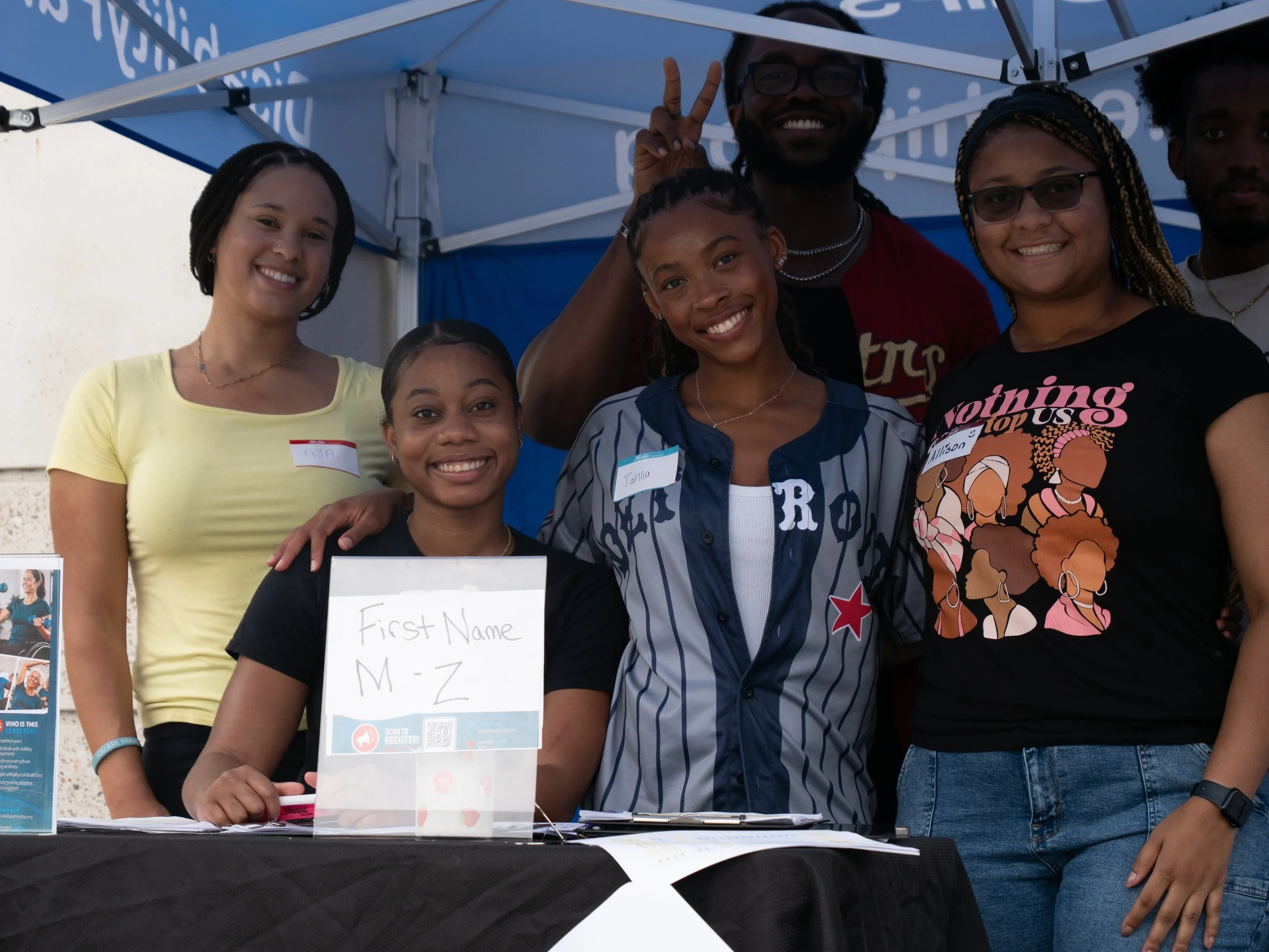 Play Without Limits volunteers smile together at the event registration table