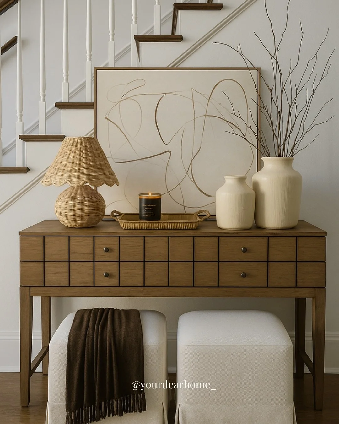 Your entryway sets the tone for your whole home ✨ This look is proof that simple can still feel elevated. From the woven lamp adding texture, to the oversized abstract art as the focal point, to the cozy ottomans tucked neatly underneath&mdash;it&rsq