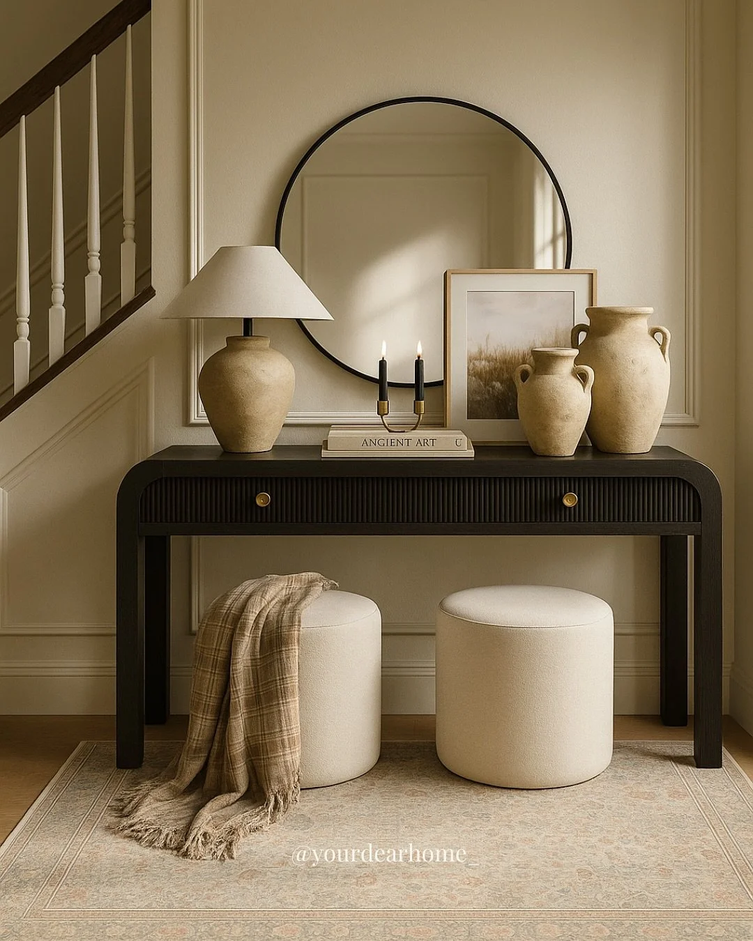 A well-styled entryway = instant first impression ✨ This look is all about pairing contrast with warmth&mdash;think a bold black console with fluted drawers, softened by handmade stoneware vases, layered art, and a cozy runner that&rsquo;s actually w