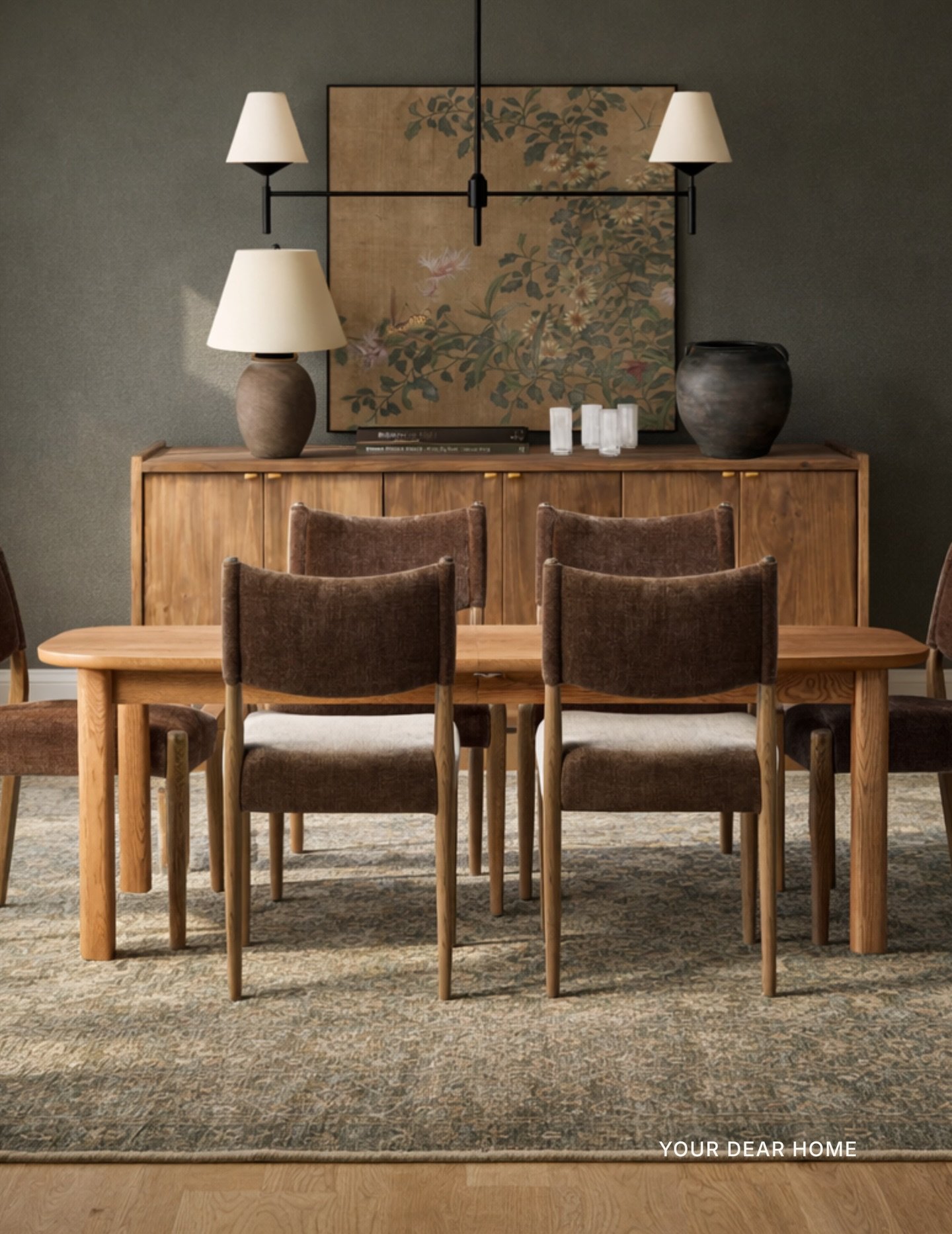 The key to a moody dining room is staying in one warm, cohesive color family.

Deep olive walls, walnut tones, chocolate velvet, when everything feels related, the space reads rich and layered instead of dark and heavy. Add one oversized art moment t