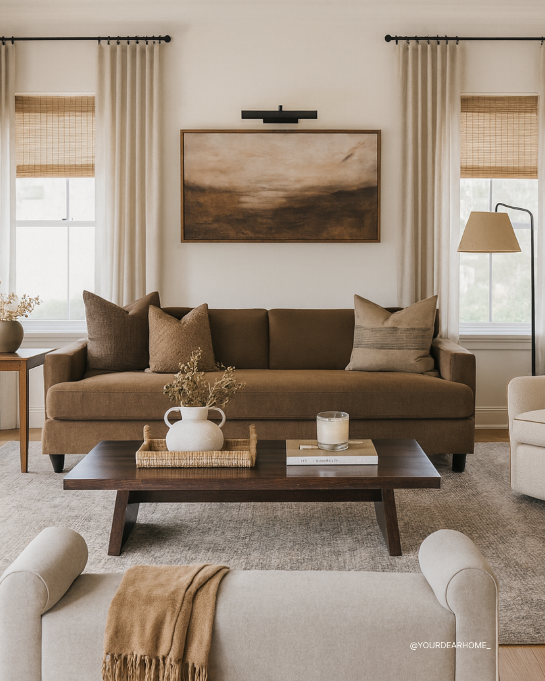 Warm neutral living room with chocolate brown sofa, creamy swivel chairs, rattan shades, and layered textiles styled in the 2026 chocolate-brown trend.