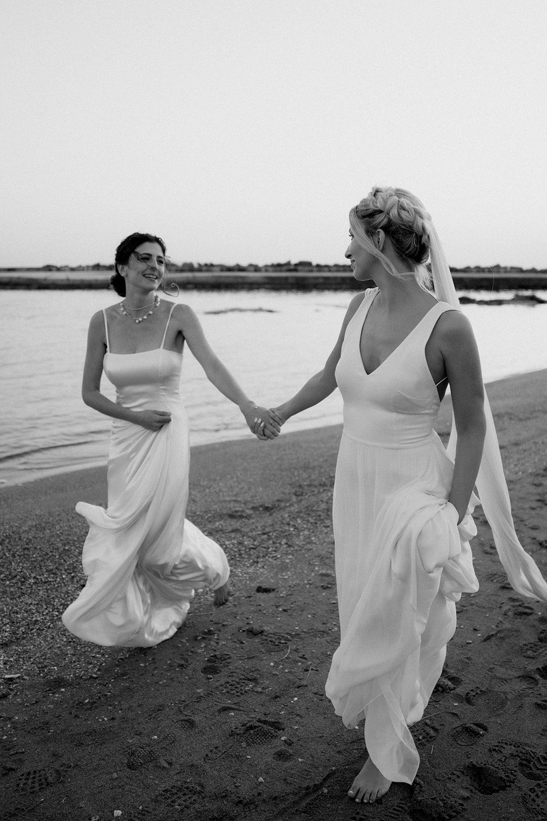 2 brides picture running on the beach in black and white
