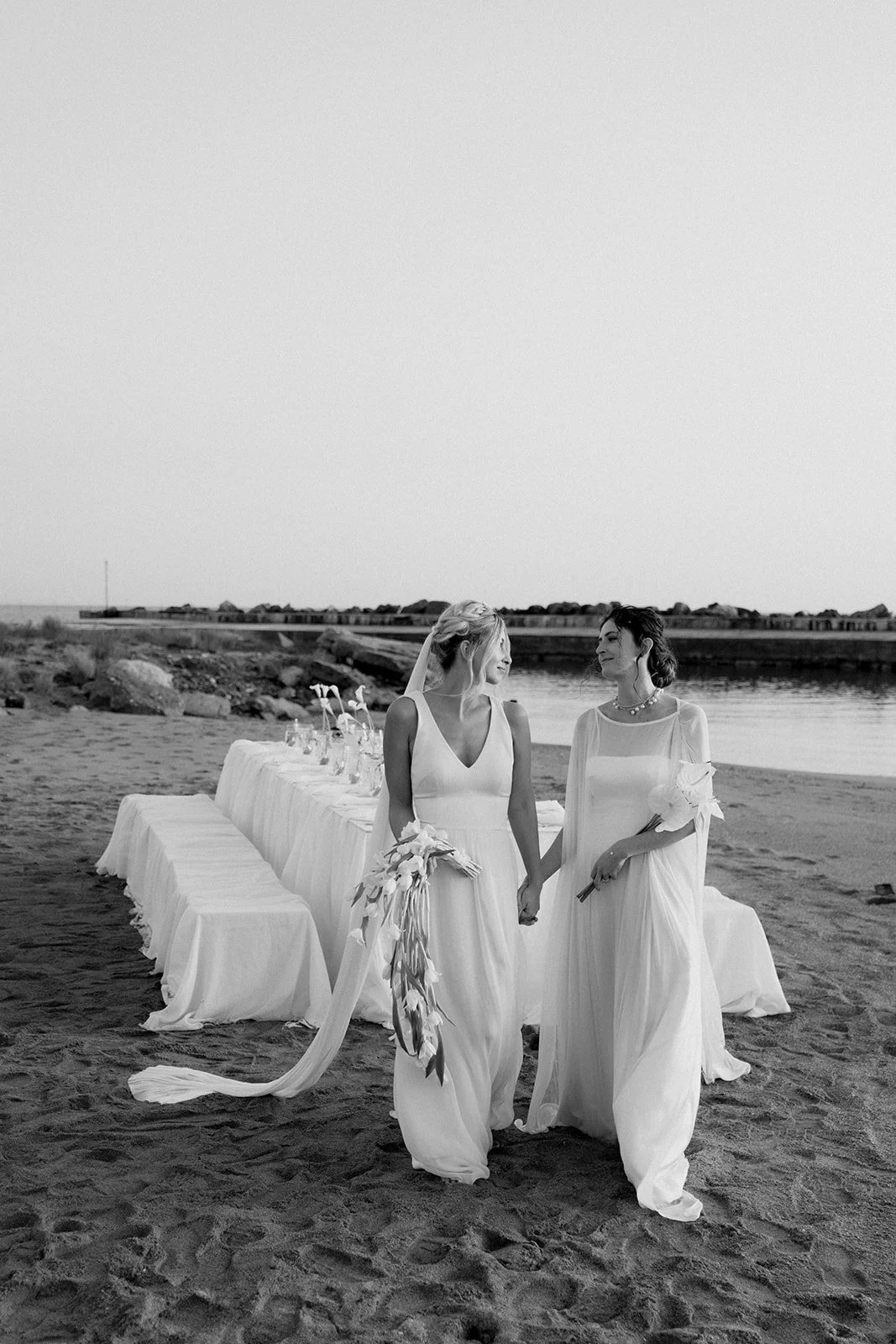 2 brides holding hands, black and white picture 