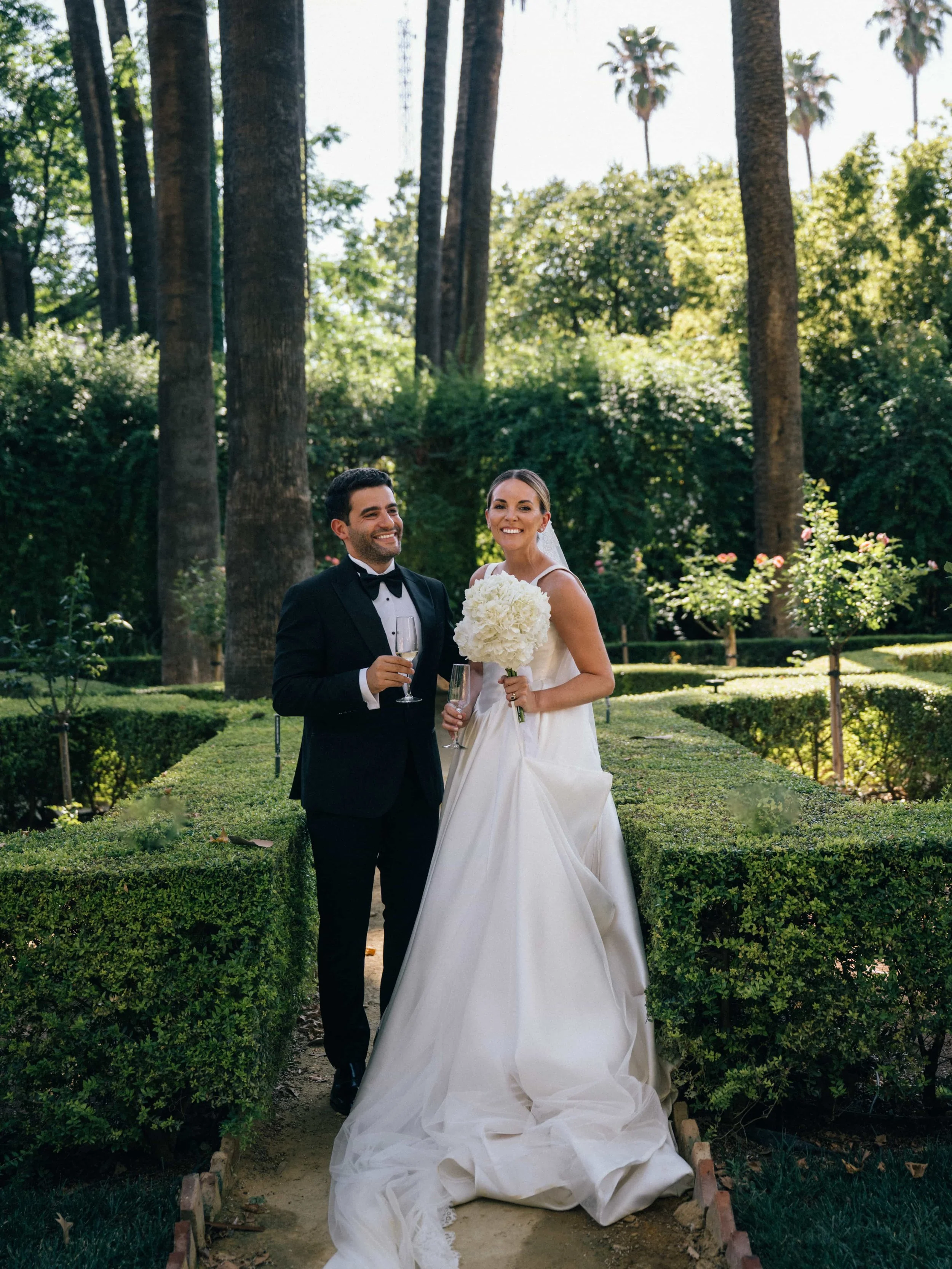 bride and groom in the garden smiling 