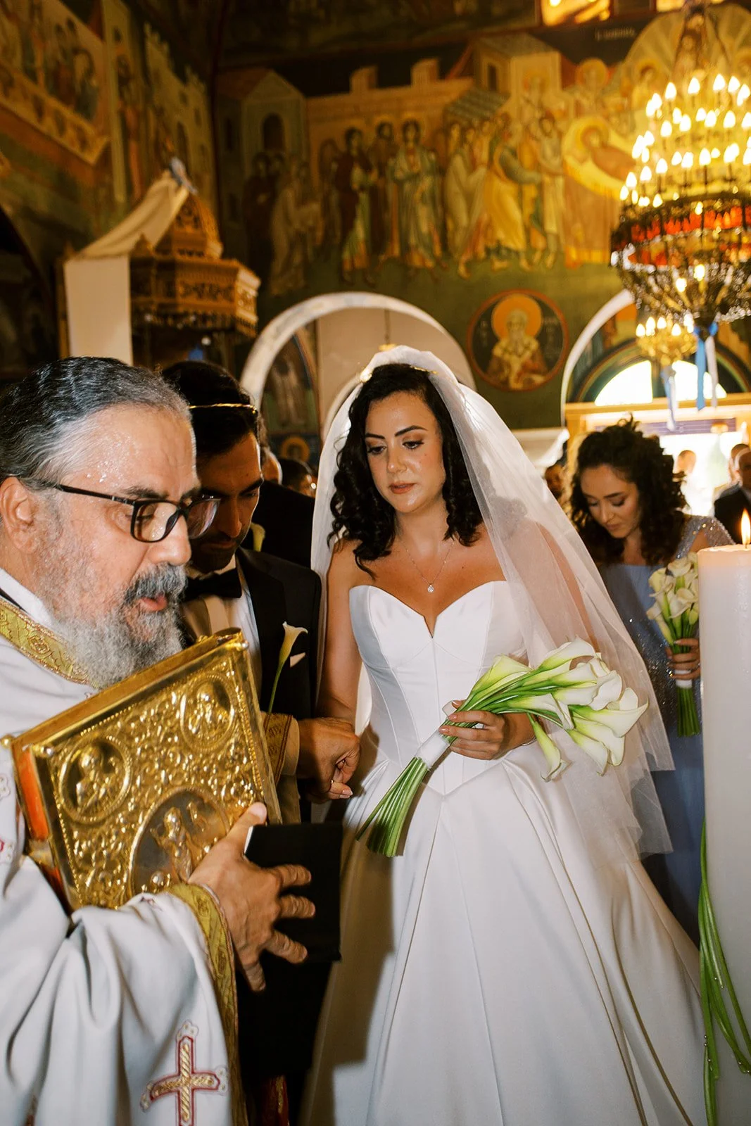 bride and groom and priest during orthodox christian ceremony