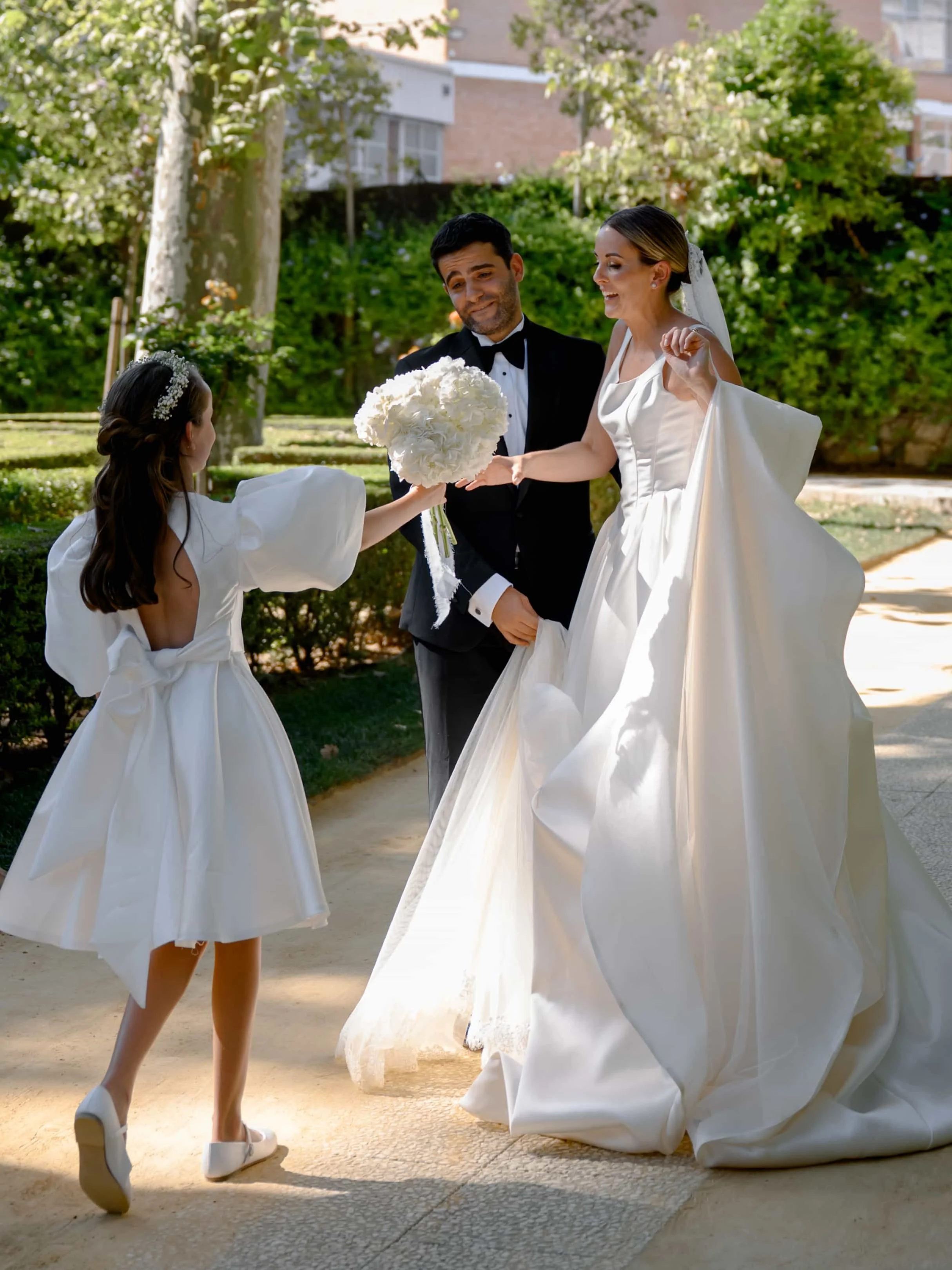flower girl giving the bridal bouquet to the bride 