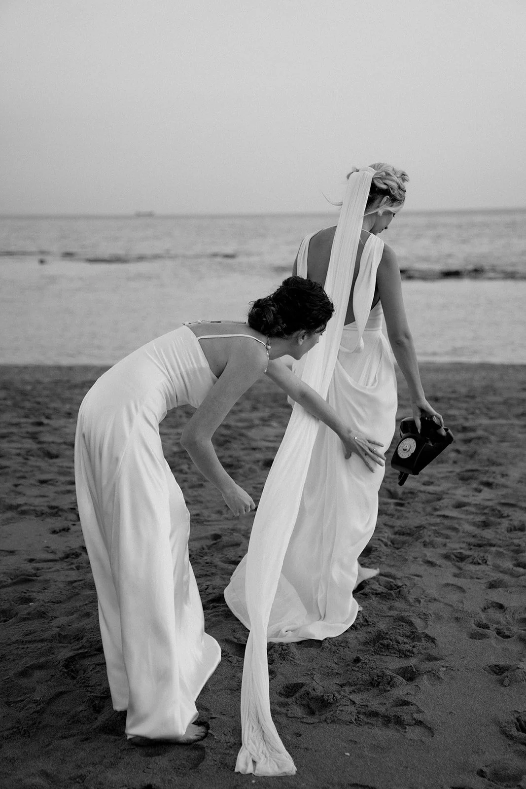 2 brides playing around on the beach