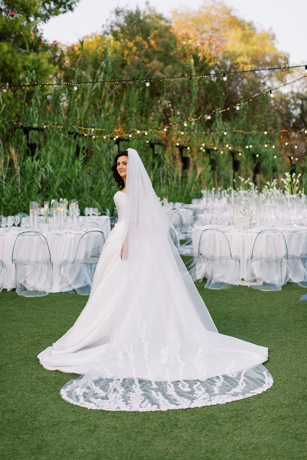 bride posing in front of the dinner tables 