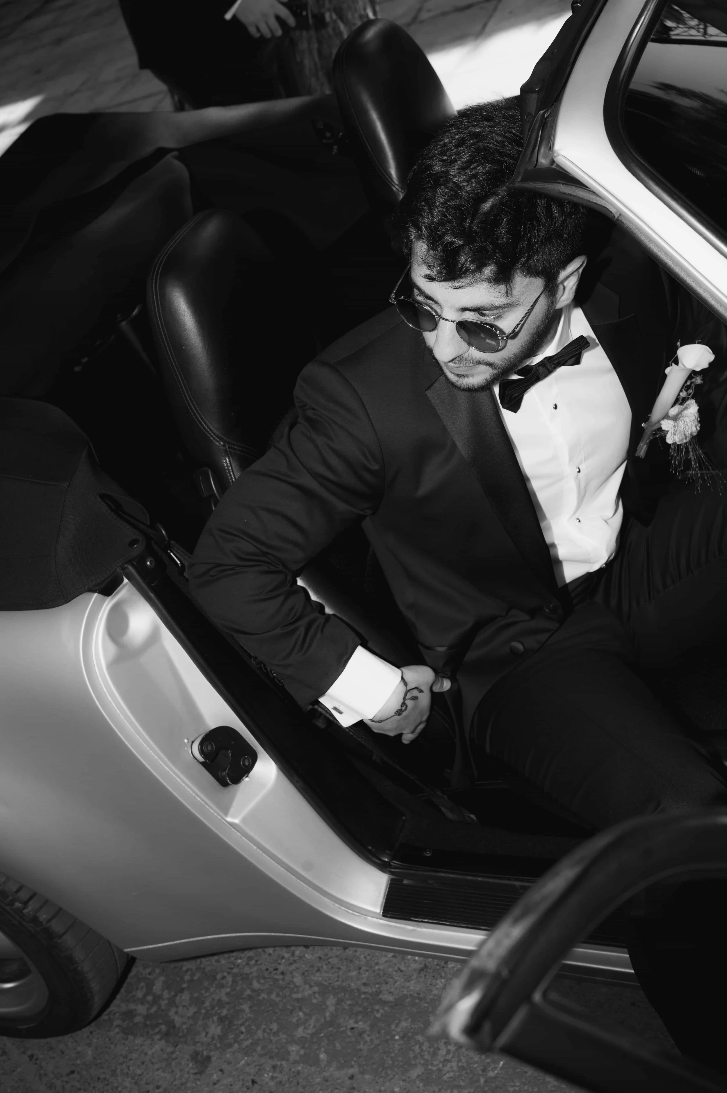 black and white shot of groom in a porsche