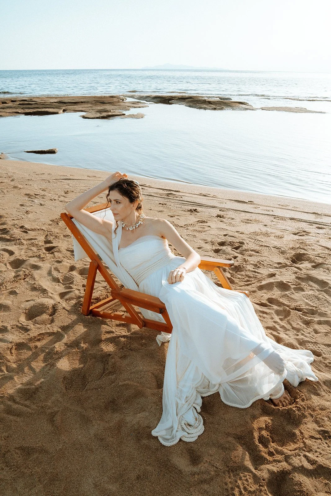 bride posing on a sun bed on the beach