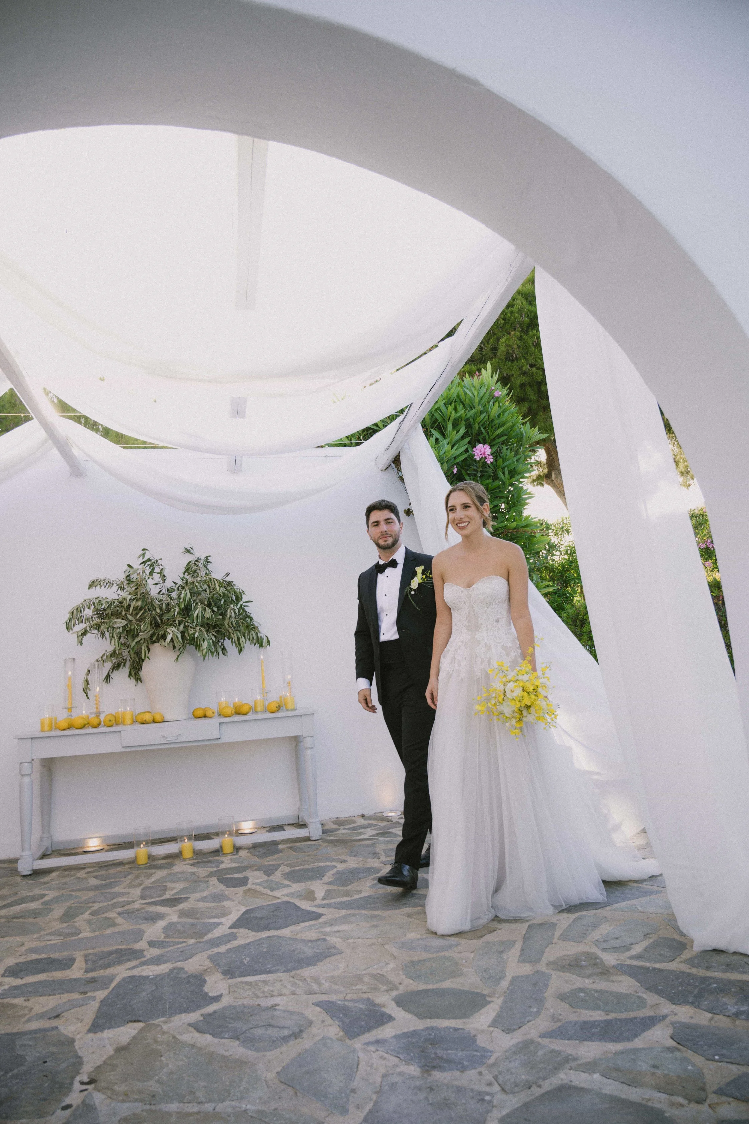 couple entering the venue with olive decoration and yellow candles