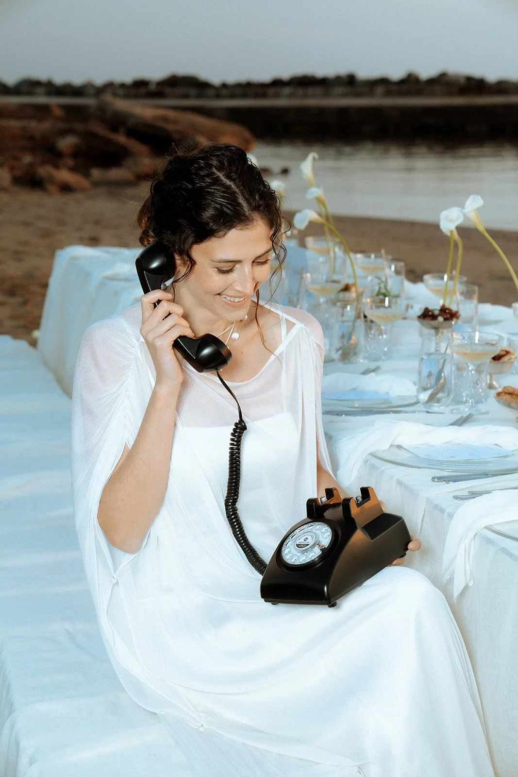bride speaking on a vintage black phone 