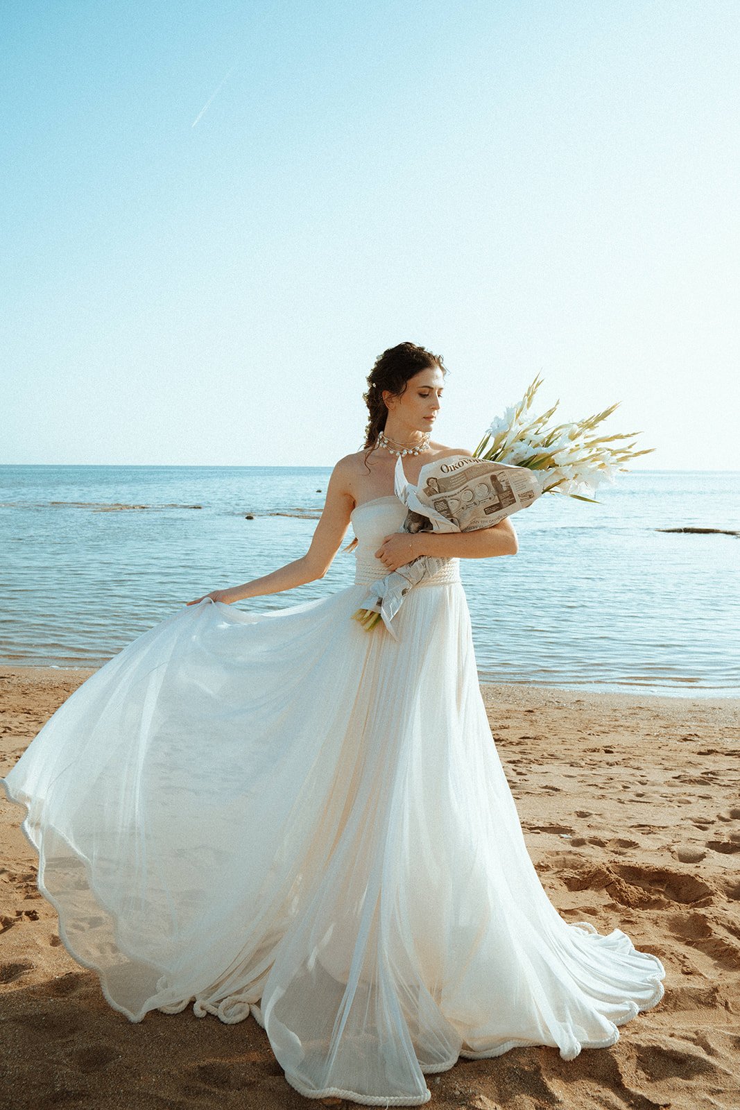 bride holding white flowers in newspaper