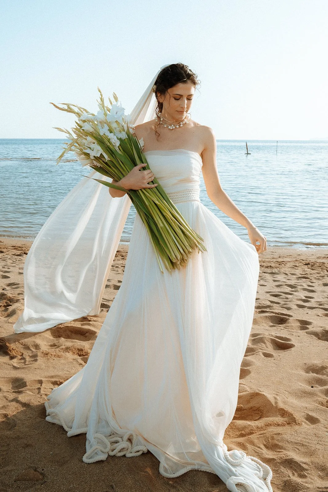 veil flying, bride posing on a beach