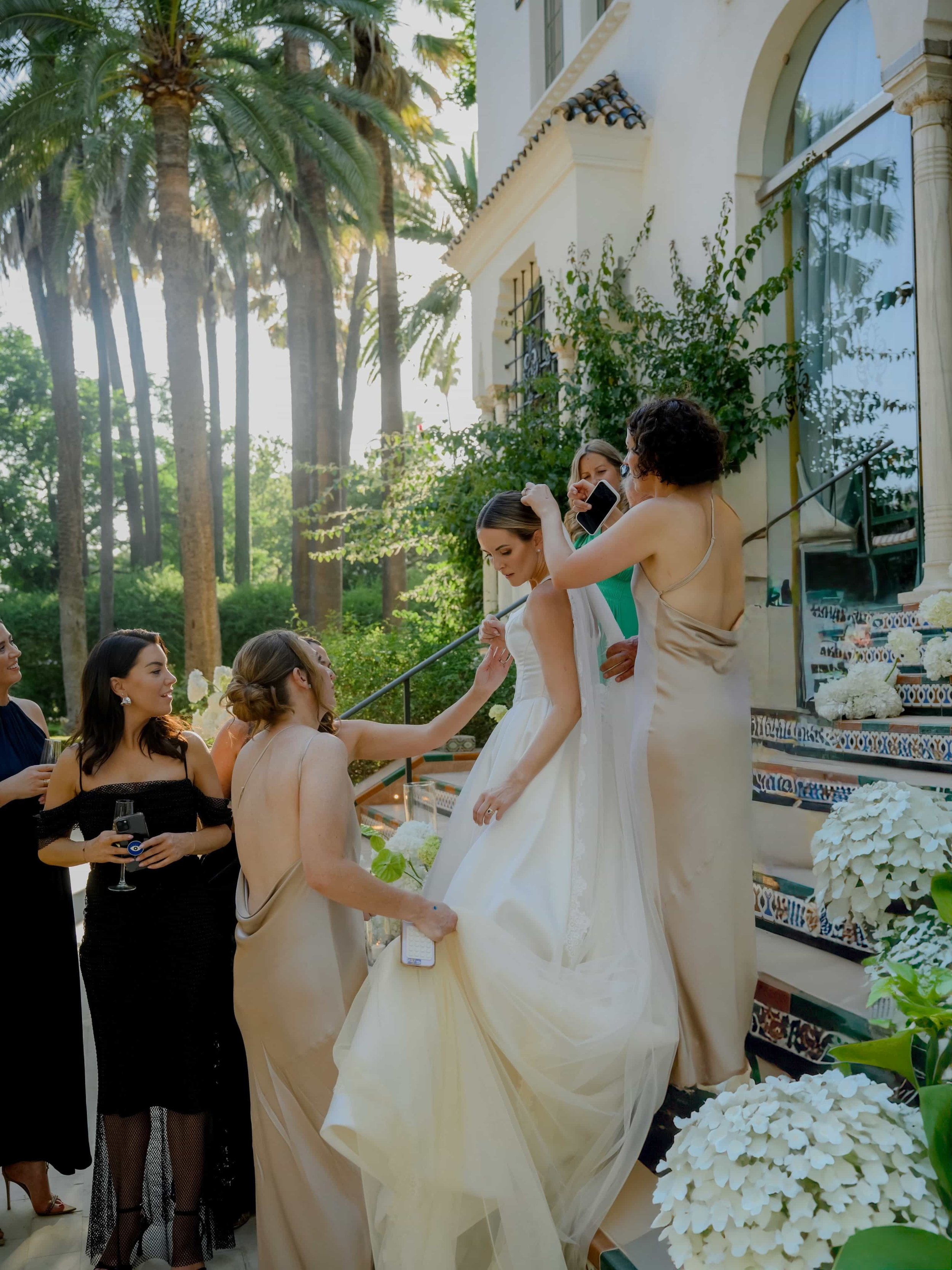Bridal party helping the bride with the dress 