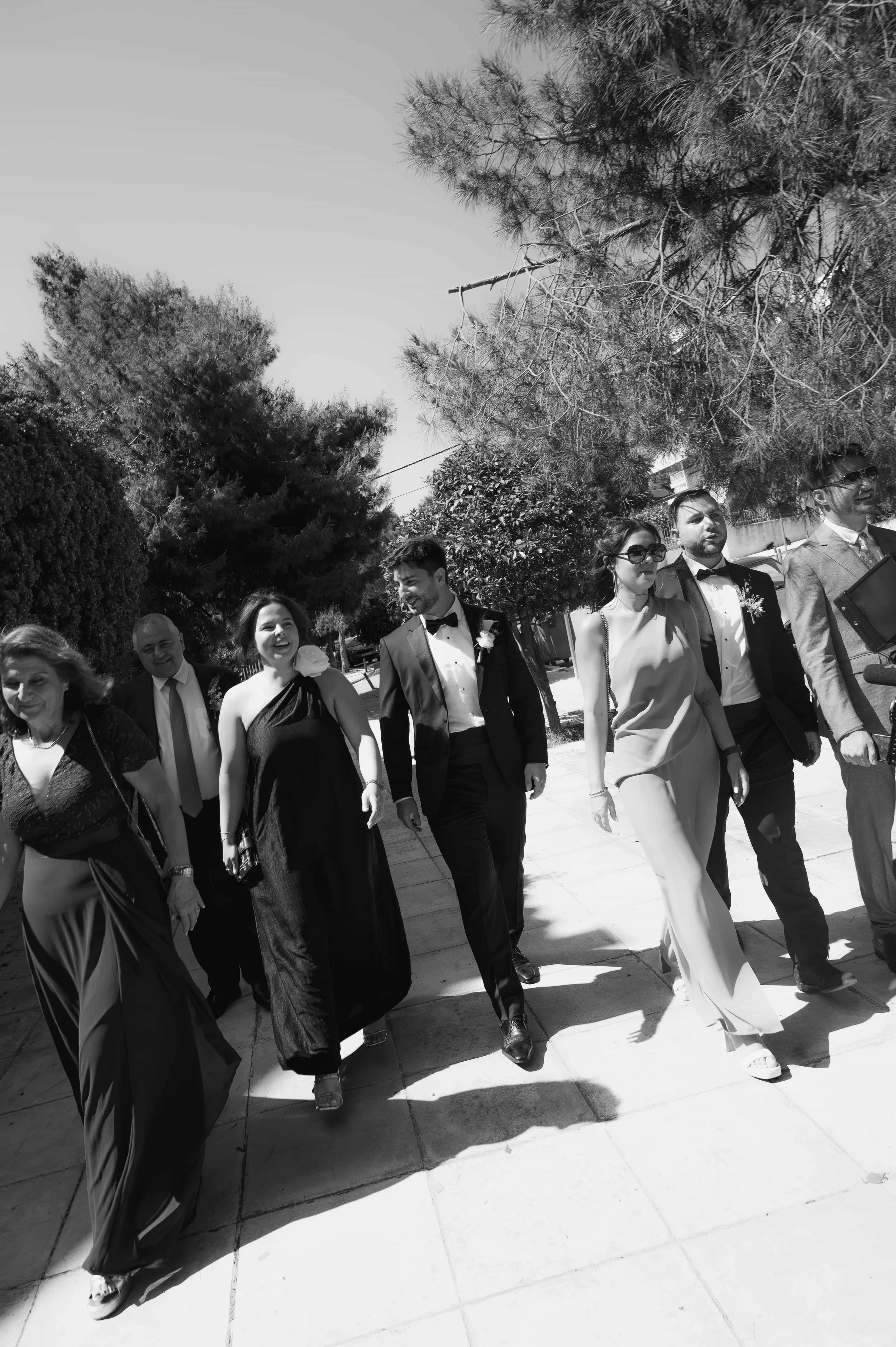 groom and family walking black and white picture