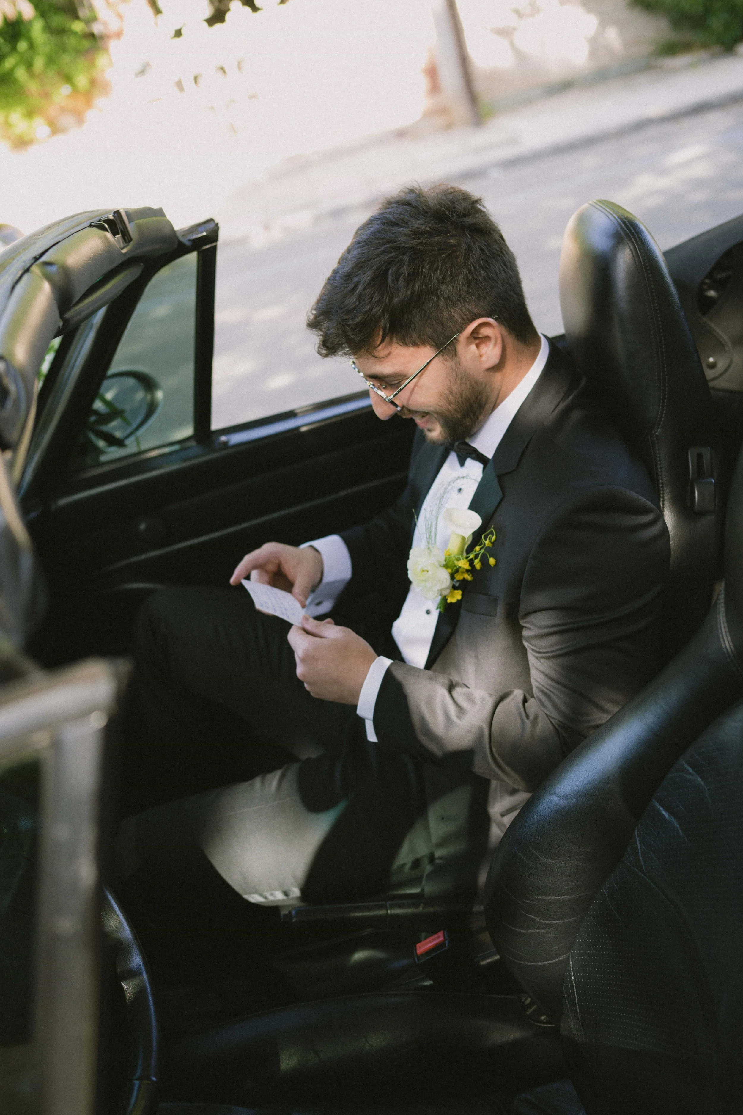 groom reading note from bride in a porsche