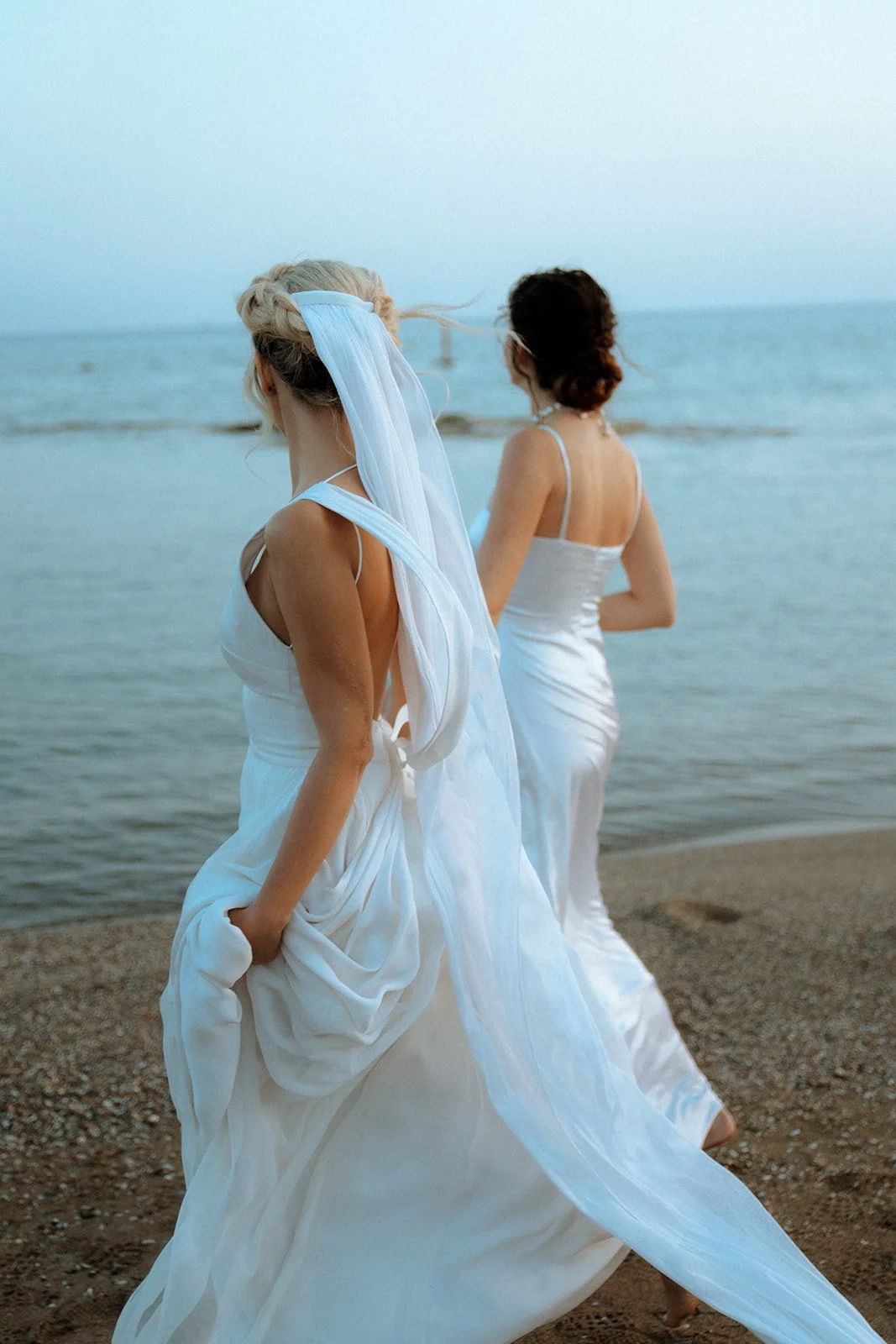 2 brides walking on the greek sea 