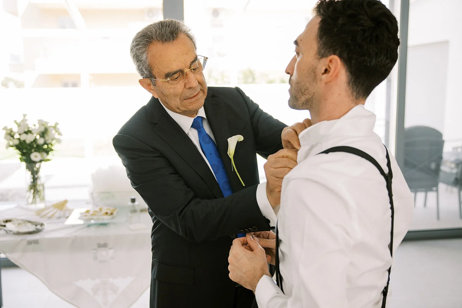 father helping the groom get dressed