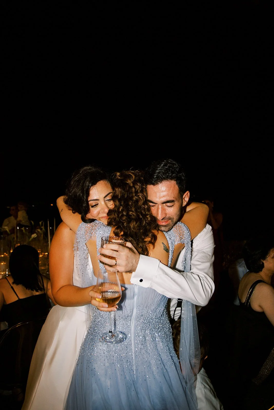 couple hugging the sister of the bride after speech 
