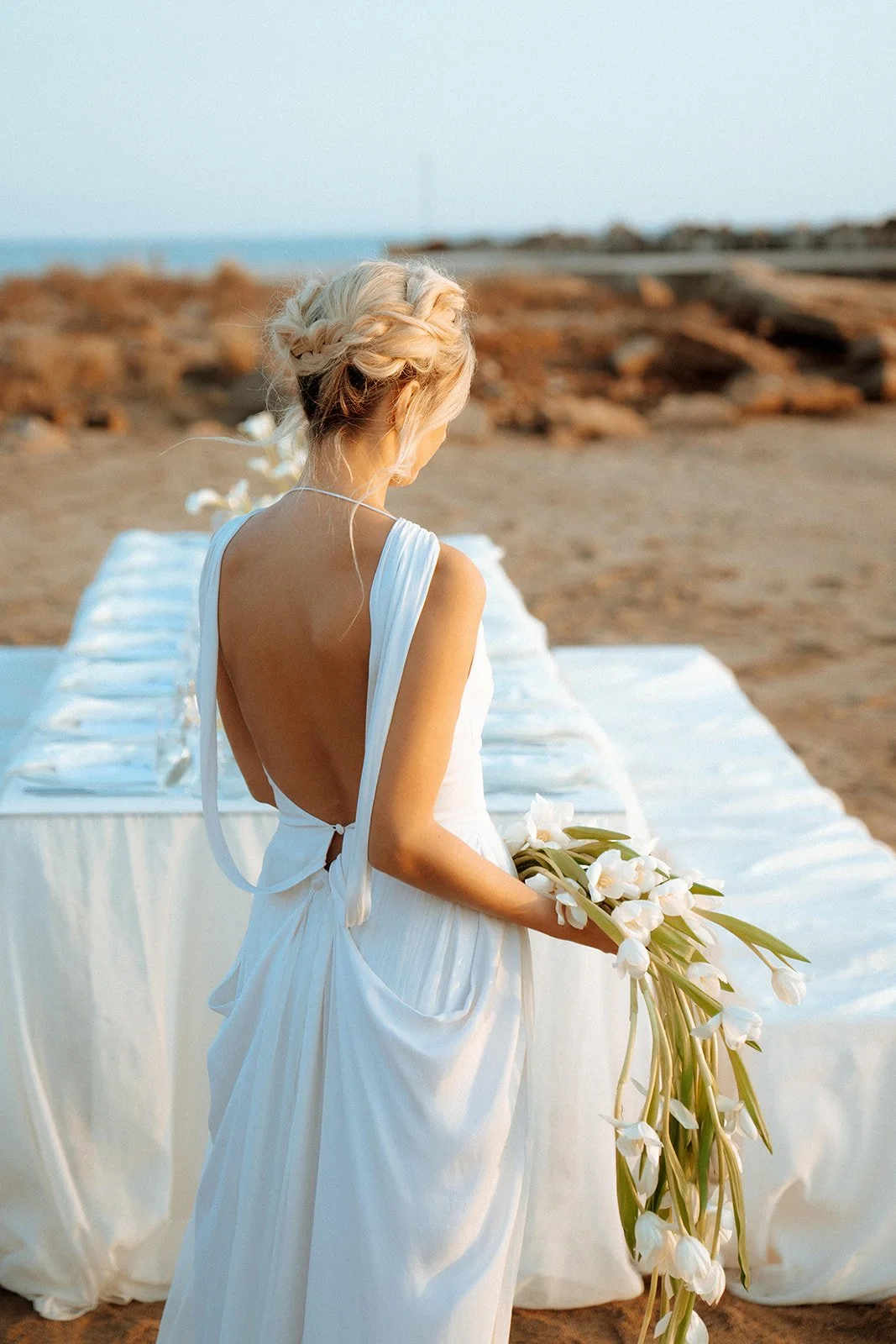 bride shot with open back dress holding a tulip bouquet