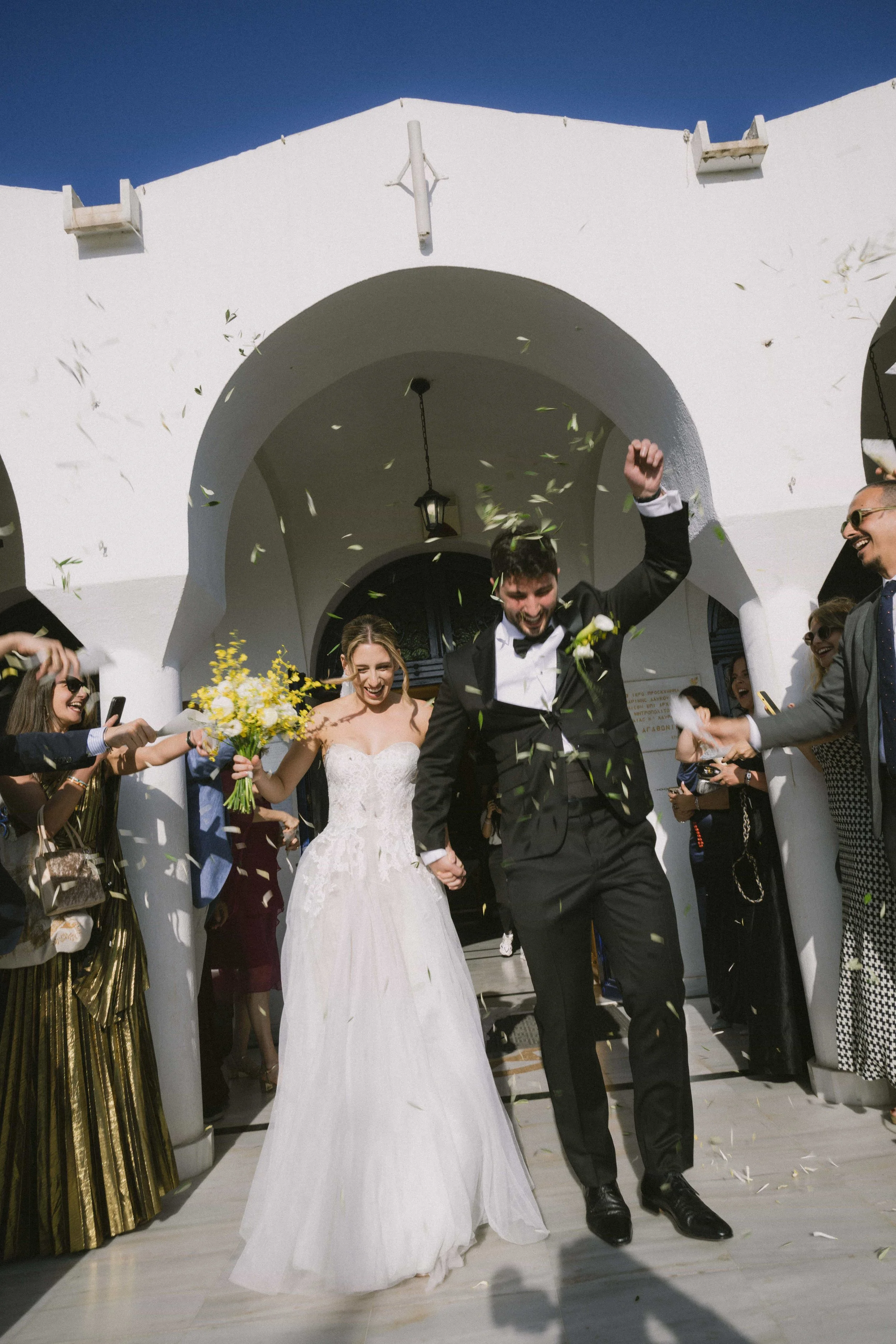 couple exit with olive petals thrown on them