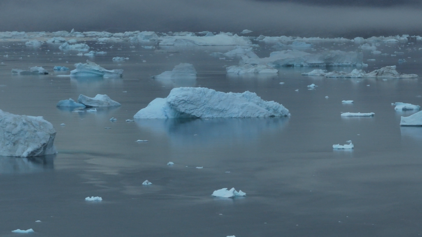 Iceberg calving into fjord in eastern Greenland