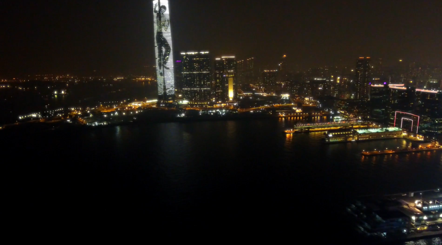 Night drone view of Victoria Harbour with International Commerce Centre and Kowloon waterfront