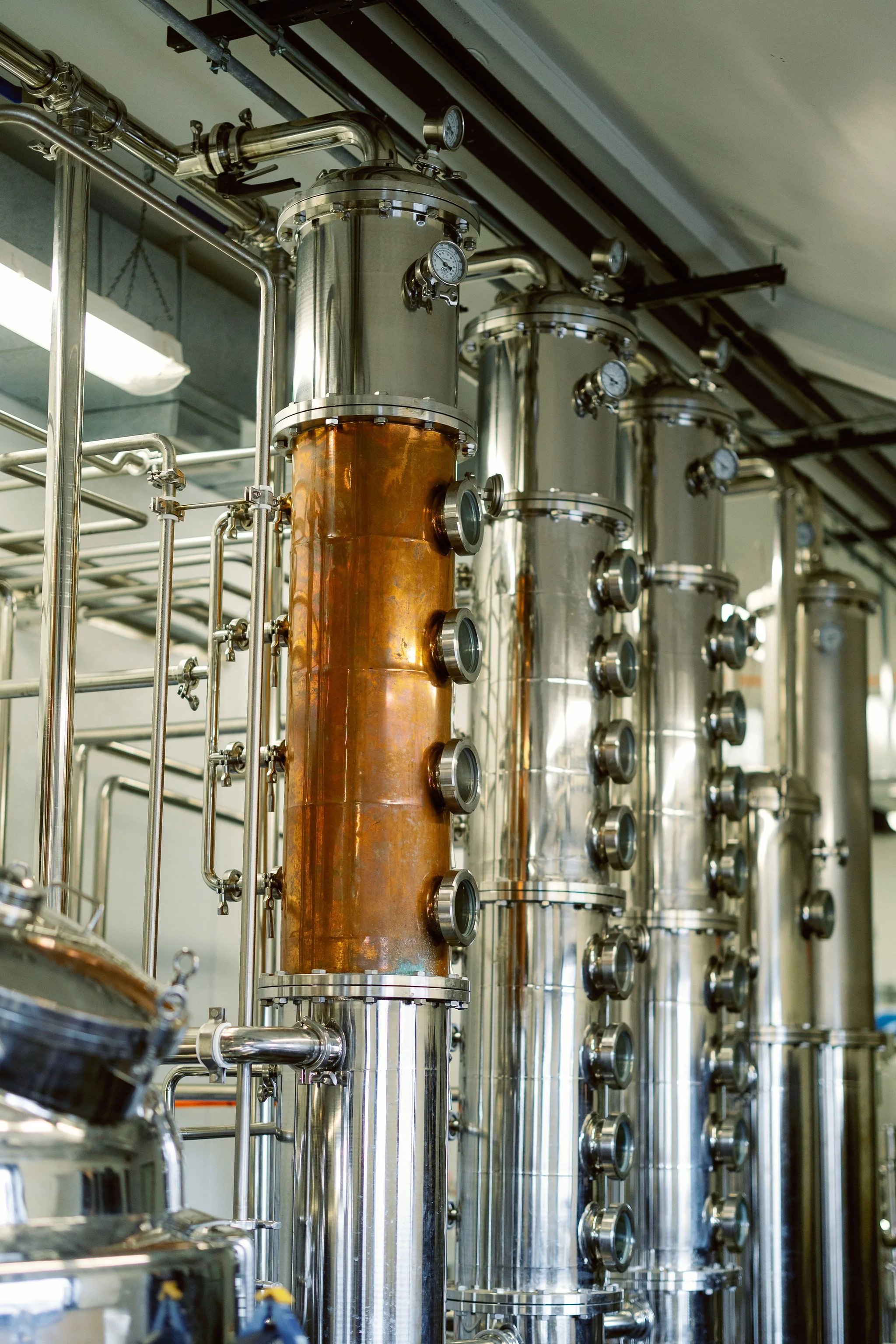 Industrial stainless steel tanks with gauges and pipelines, used in a manufacturing or processing facility.