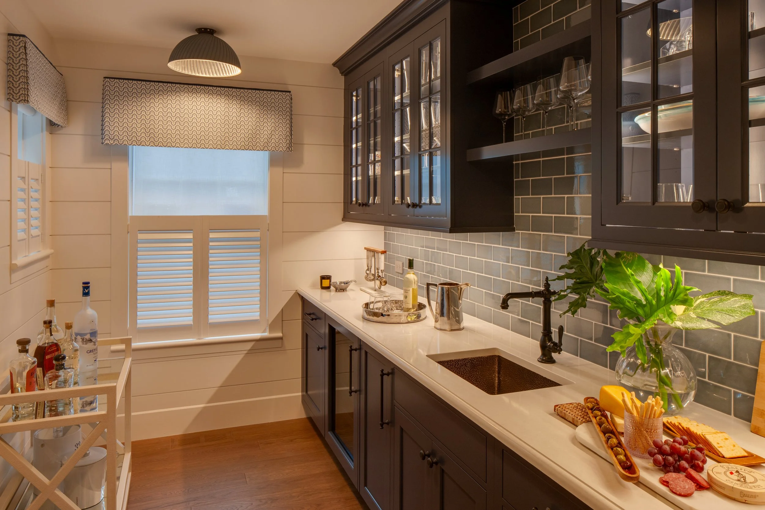 custom cabinetry with dark stain, wet bar with floating shelves and glass doors
