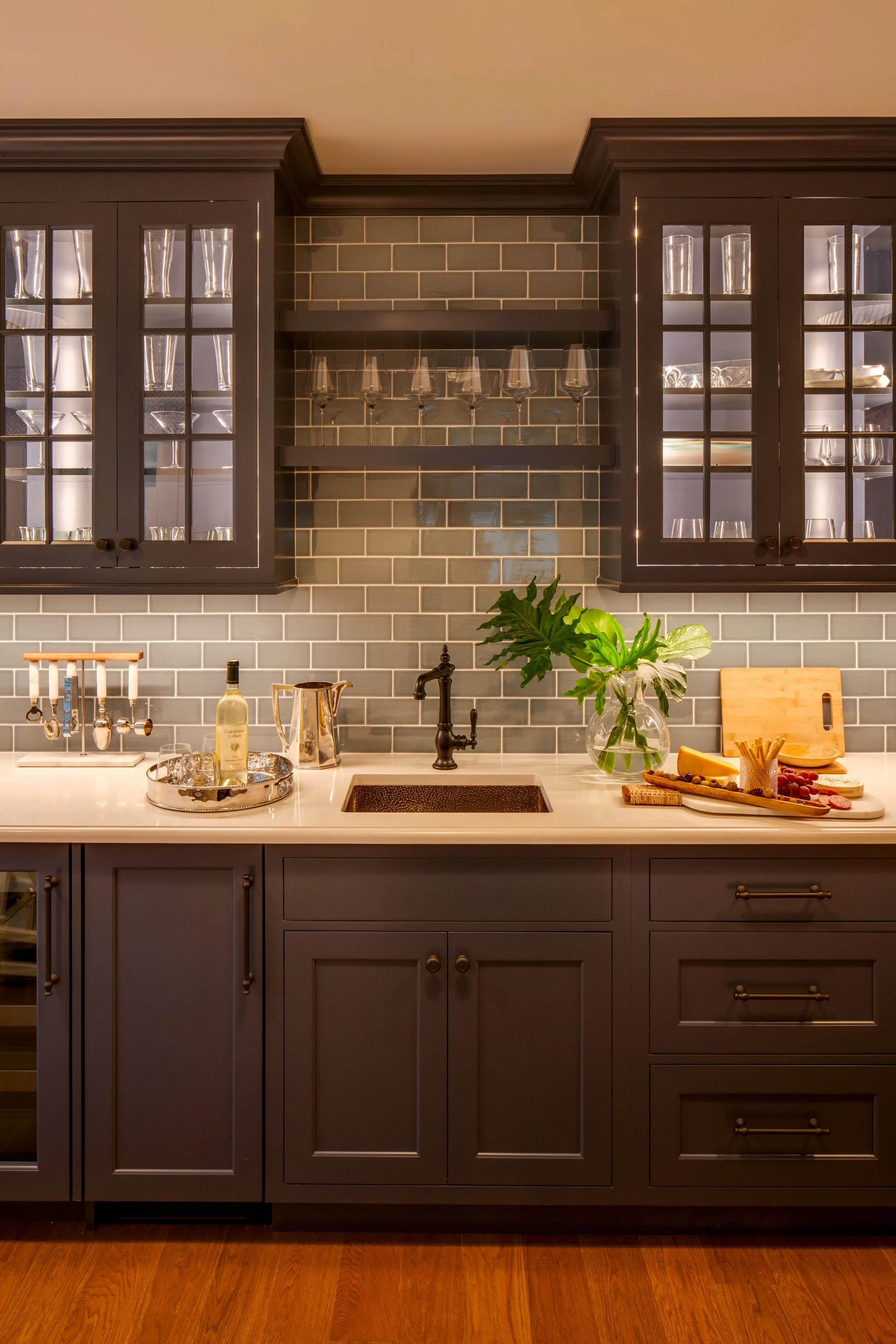 custom cabinetry with dark stain, wet bar with floating shelves and glass doors